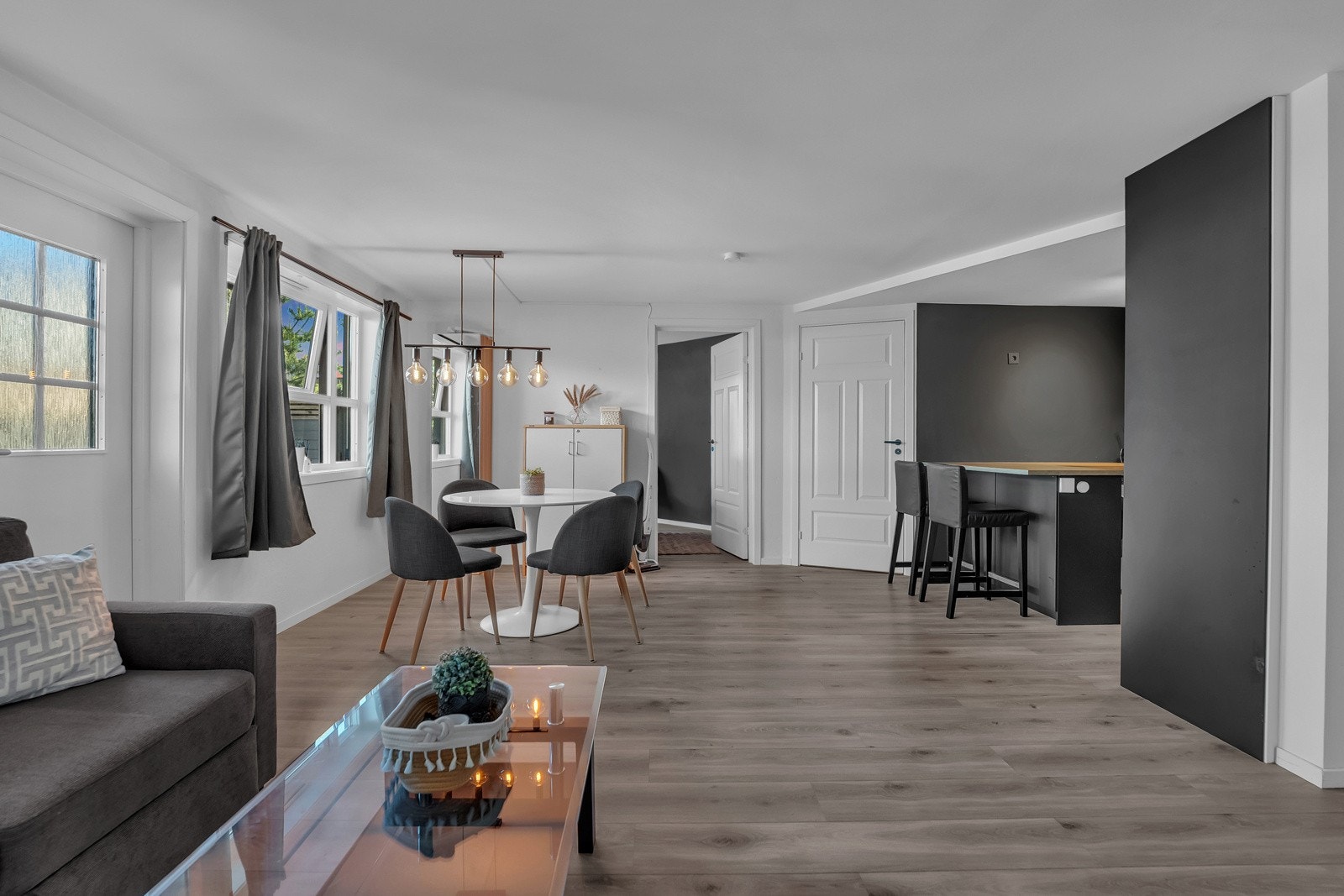 Hybelen (ikke godkjent ihht tegninger) har direkte inngang til stuen, som har laminatgulv, gode vindusflater, hvitmalt, glatt himling, samt glatte vegger malt i hvitt med helt mørke fondvegger mot kjøkkenet. Rommet har god plass til både sofa og spisebord Galleribilde