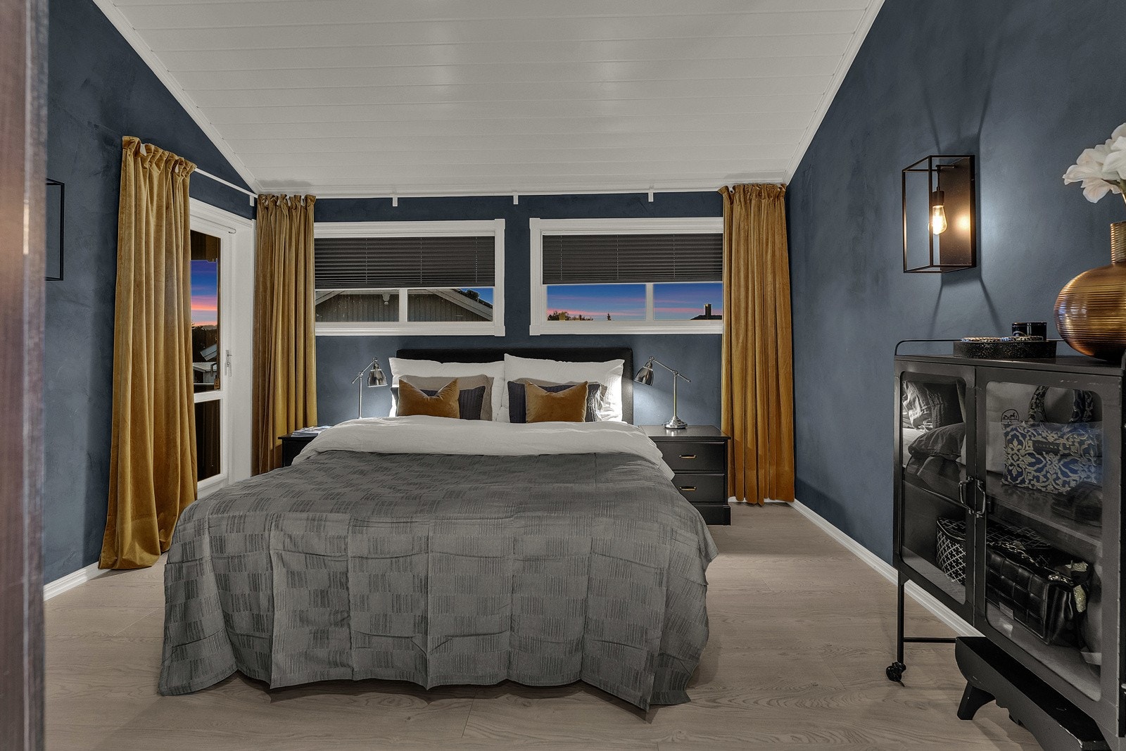 Hovedsuiten har adkomst via badet og utgang til den store terrassen med basseng. Hovedsoverommet har vegger malt i støvblå kalkmaling, skråtak i hvitmalt panel og enstavs laminatgulv, samt en skyvedørsgarderobe i baderomsdelen Galleribilde