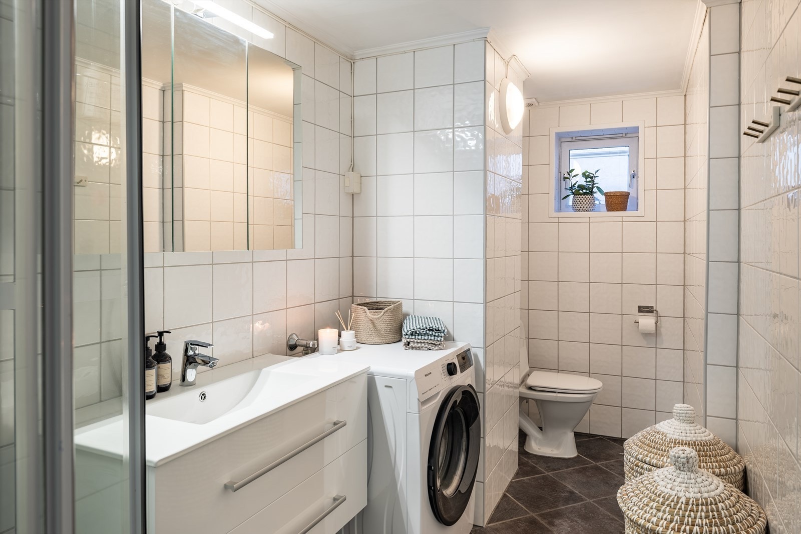 Badet har ny baderomsinnredning (2025) og speilskap med LED-lys. Videre er det toalett, dusjkabinett, opplegg for vaskemaskin og behagelig varme i gulv. Dobbeltstikk klart dersom man ønsker å ha tørketrommel over vaskemaskinen. Galleribilde