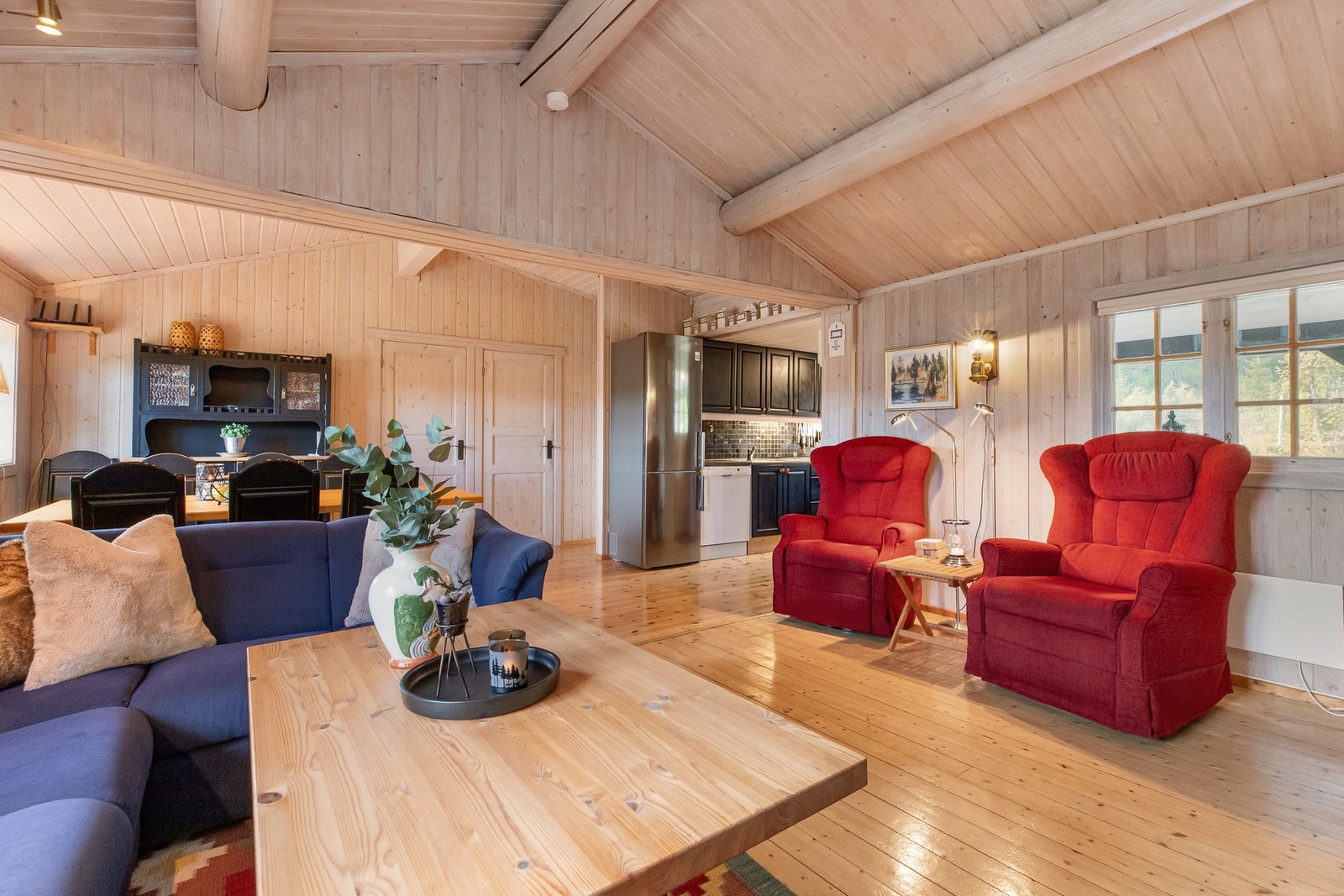 I den eldre delen av stua er himlingen røstet med tømmeråser, og i den nyere spisestuedelen med limtre Galleribilde