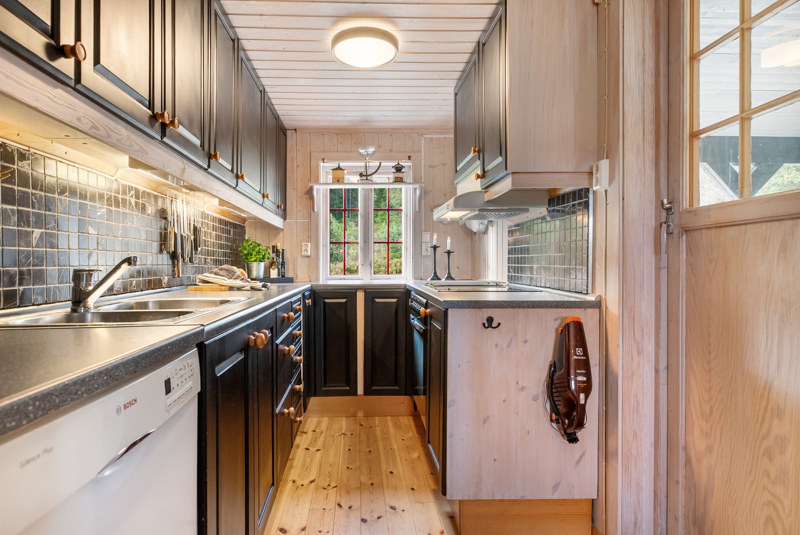 Kjøkkenet har kjøkkeninnredning i folierte plater og malte fronter med over-og underskap, laminat benkeplate i trefylling Galleribilde