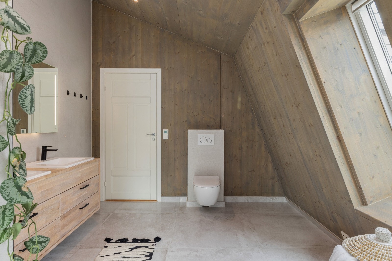 Rommets vegger har en blanding av fliser, mikrosement og panel/tre, noe som skaper fine kontraster. Galleribilde