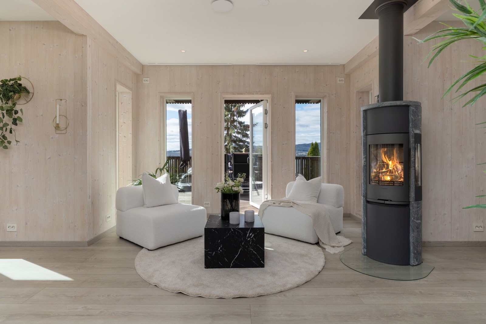 Gulvet er belagt med høytrykkslaminat i moderne utførelse, og rommet har en flott vedovn av typen Contura med klebersteinsomramming. Galleribilde