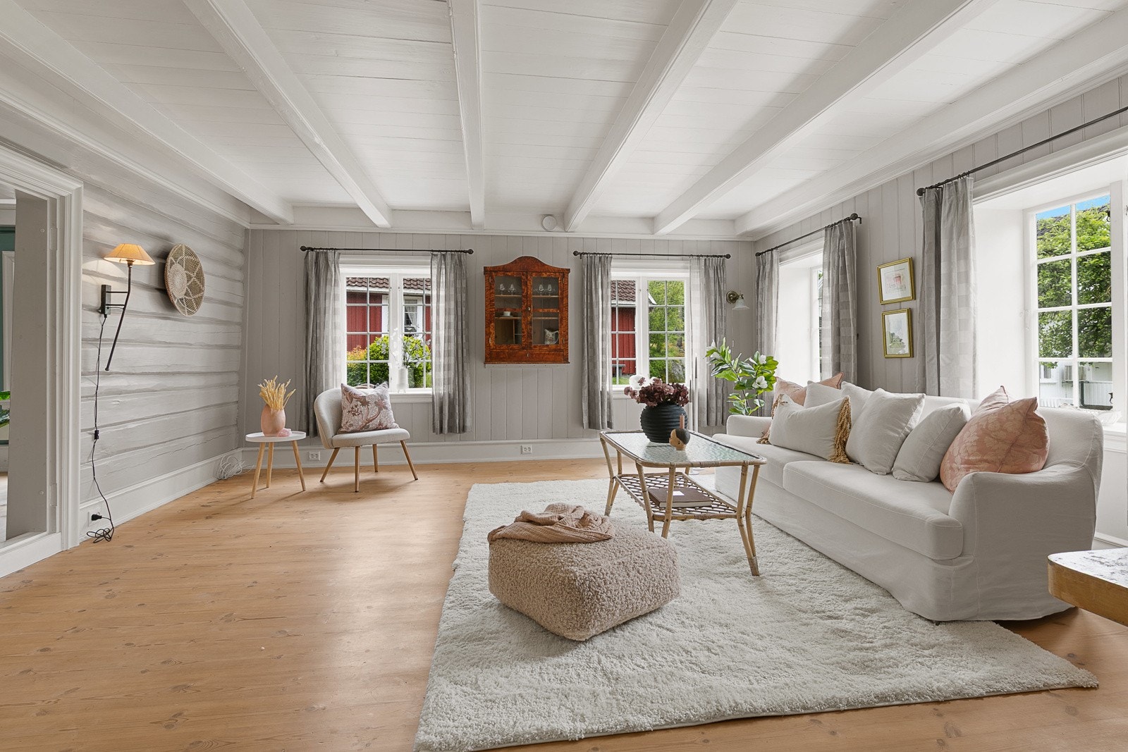 Stua får mye naturlig lys fra store vindusflater Galleribilde