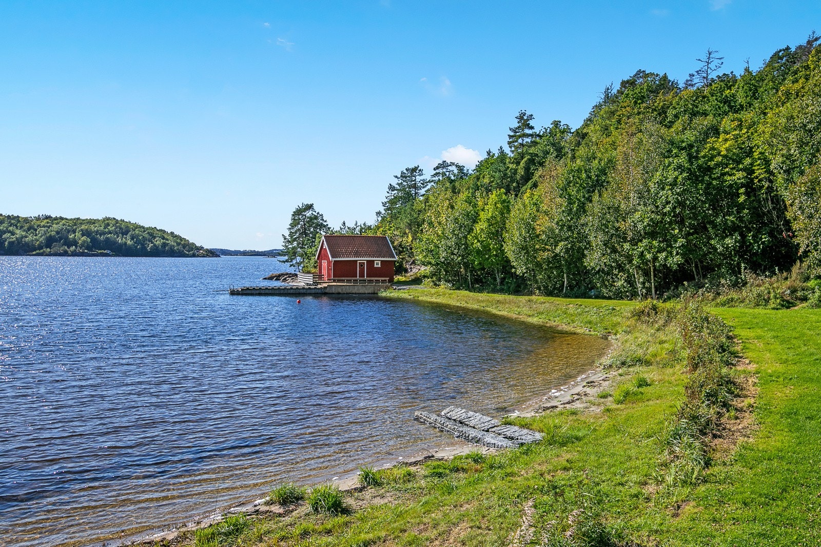 En idyllisk eiendom ved sjøen bestående av totalt 6 bygg, inkludert dette sjøhuset i vannkanten Galleribilde