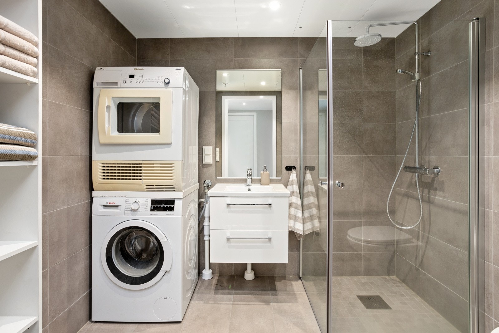 Pen dusjsone med glassdører og opplegg for vaskemaskin. Galleribilde