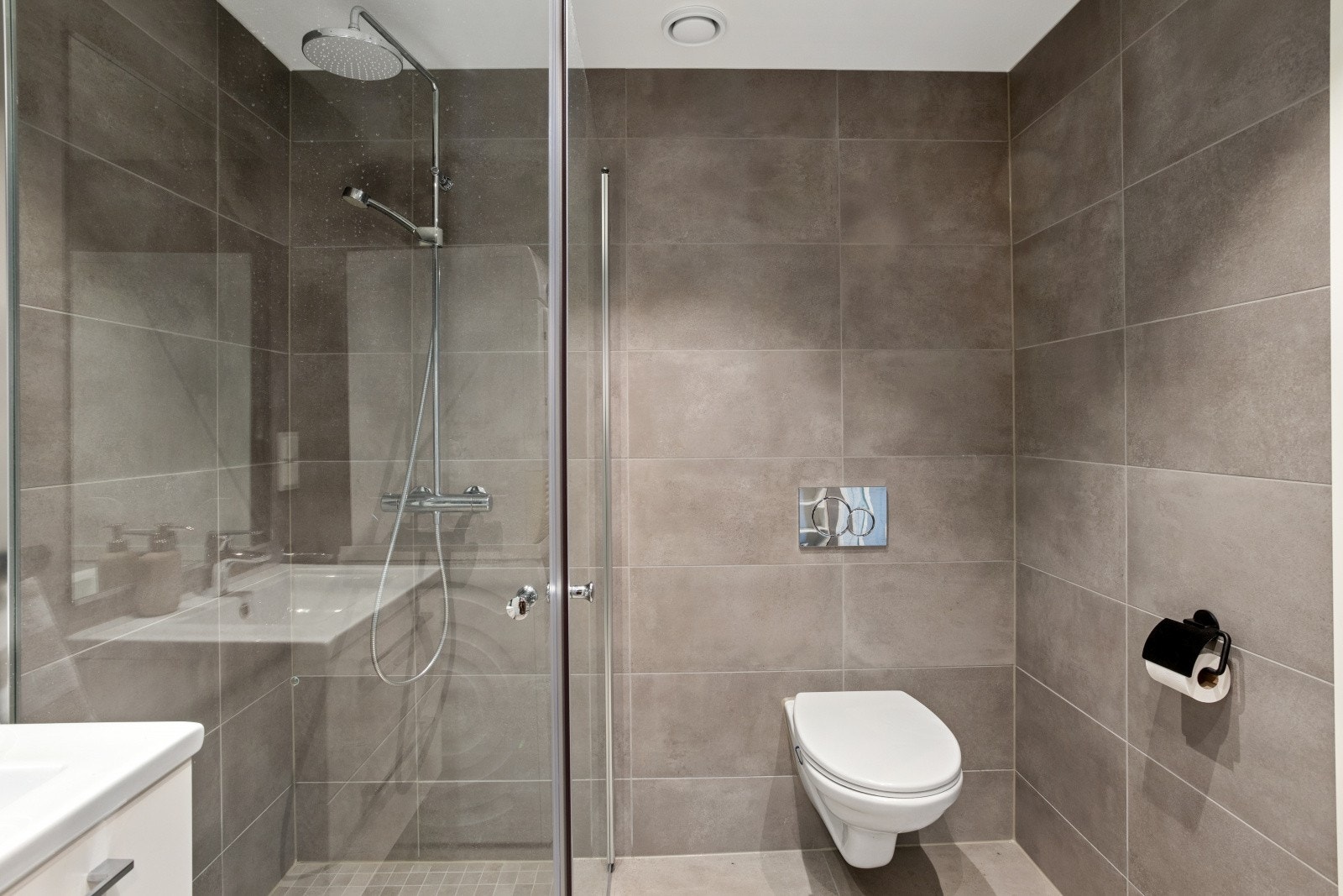 Bad er romslig og moderne, med flislagte vegger og gulv. Det er innredet med servant, skuffeseksjon og vegghengt toalett. Galleribilde