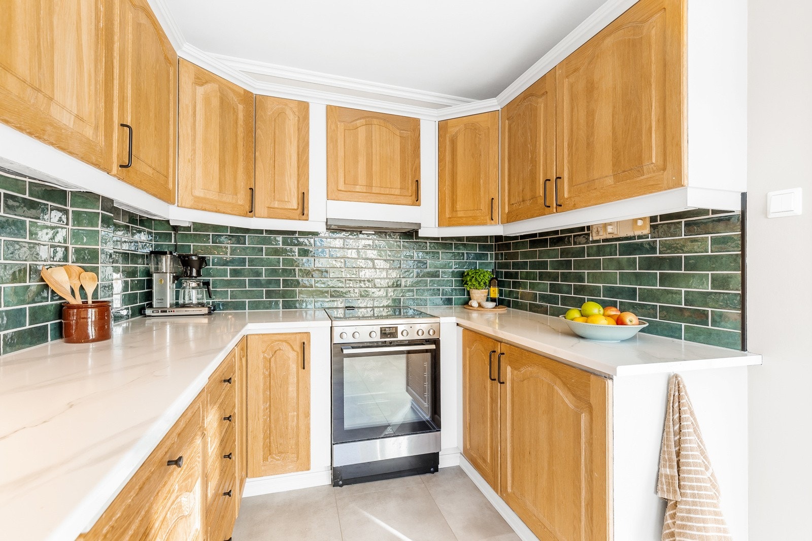 Praktisk innredet kjøkken med god skap -og benkeplass. Galleribilde