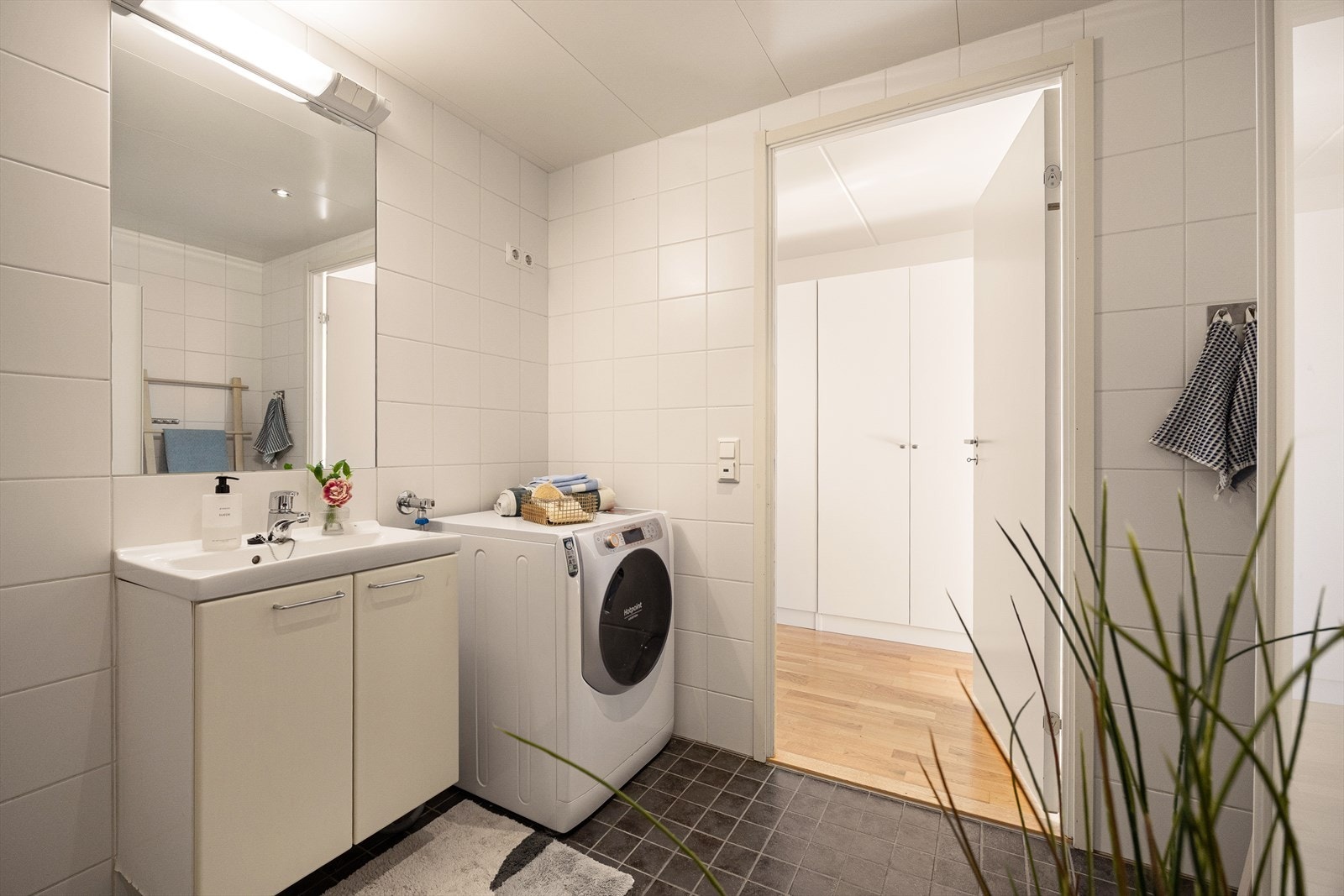 Badet har dusjnisje, servant med innredning, toalett og opplegg for vaskemaskin. Galleribilde