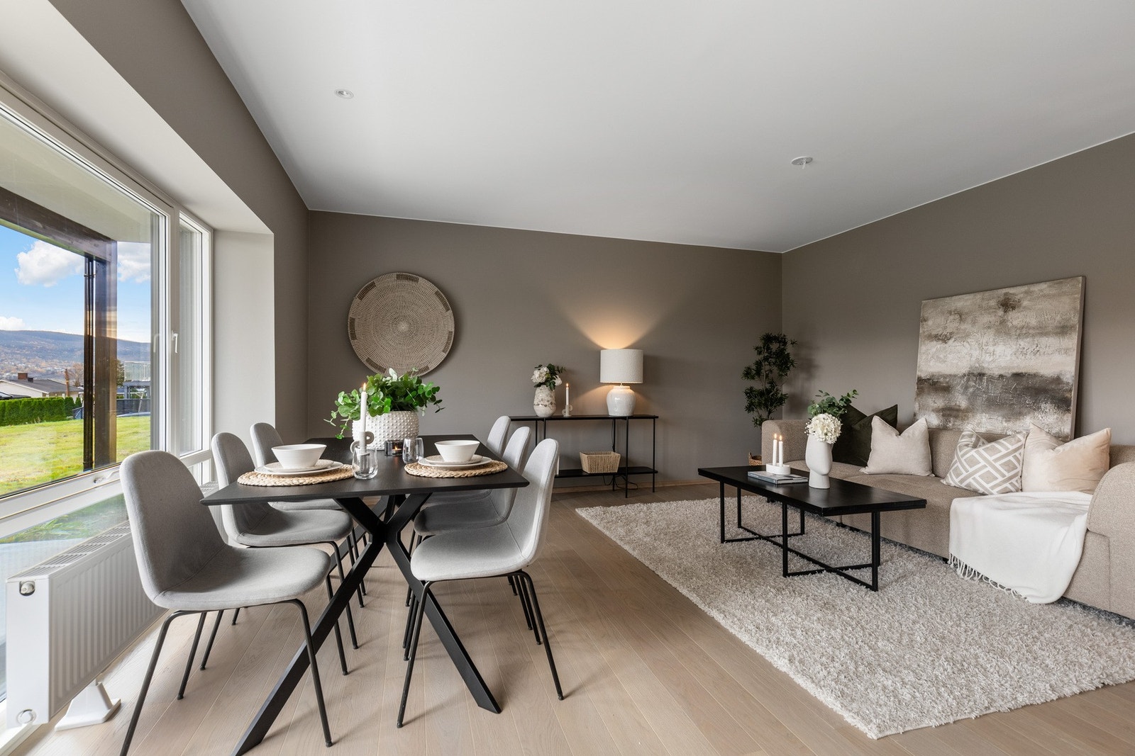 Lys og romslig stue med plass til spiseplass ved vinduet og sofakrok. Galleribilde