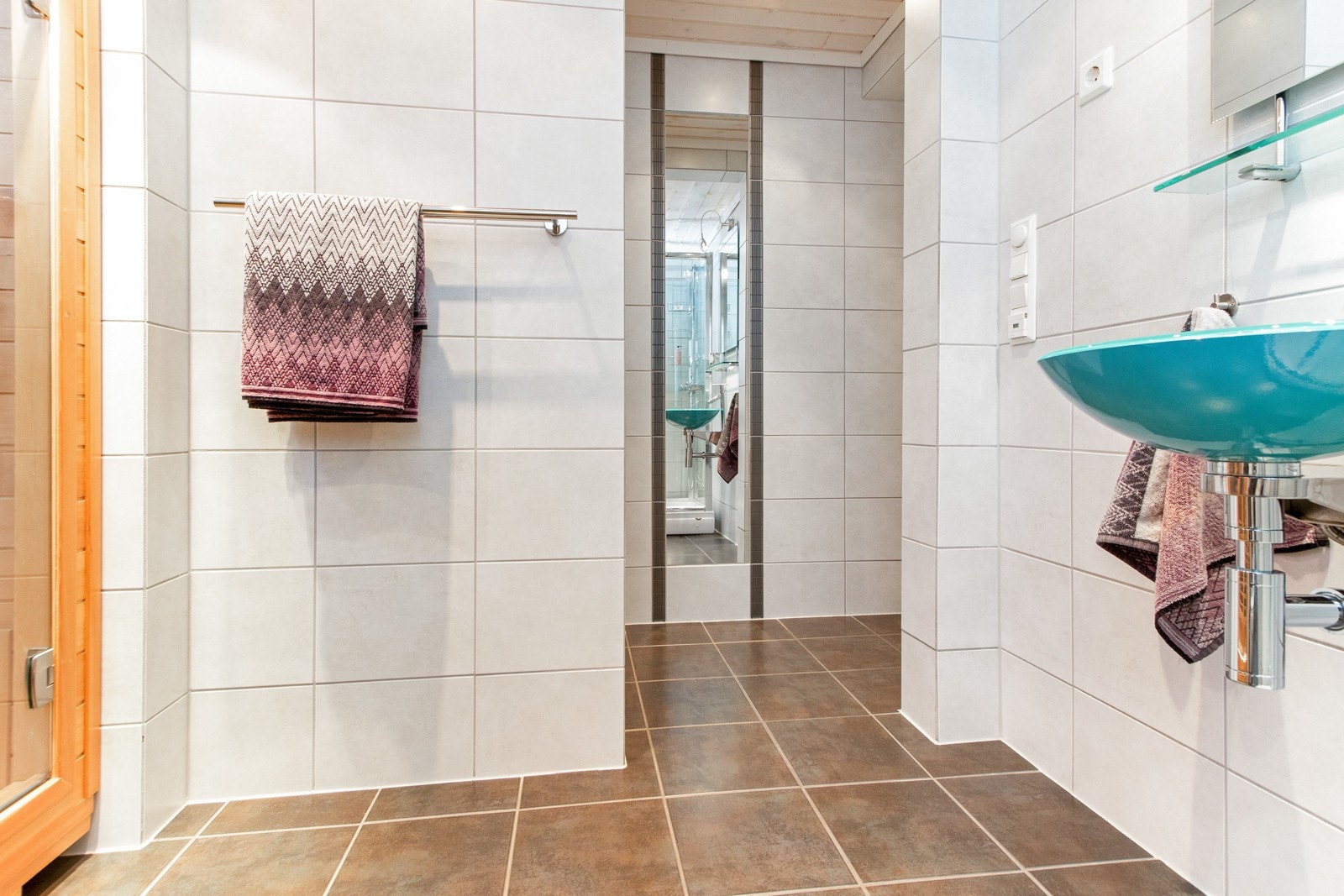 Badet i underetasjen er fra 2007 og har mørke fliser på gulvet, lyse fliser på veggene, gulvvarme, dusjkabinett og elektrisk avtrekksvifte. Galleribilde