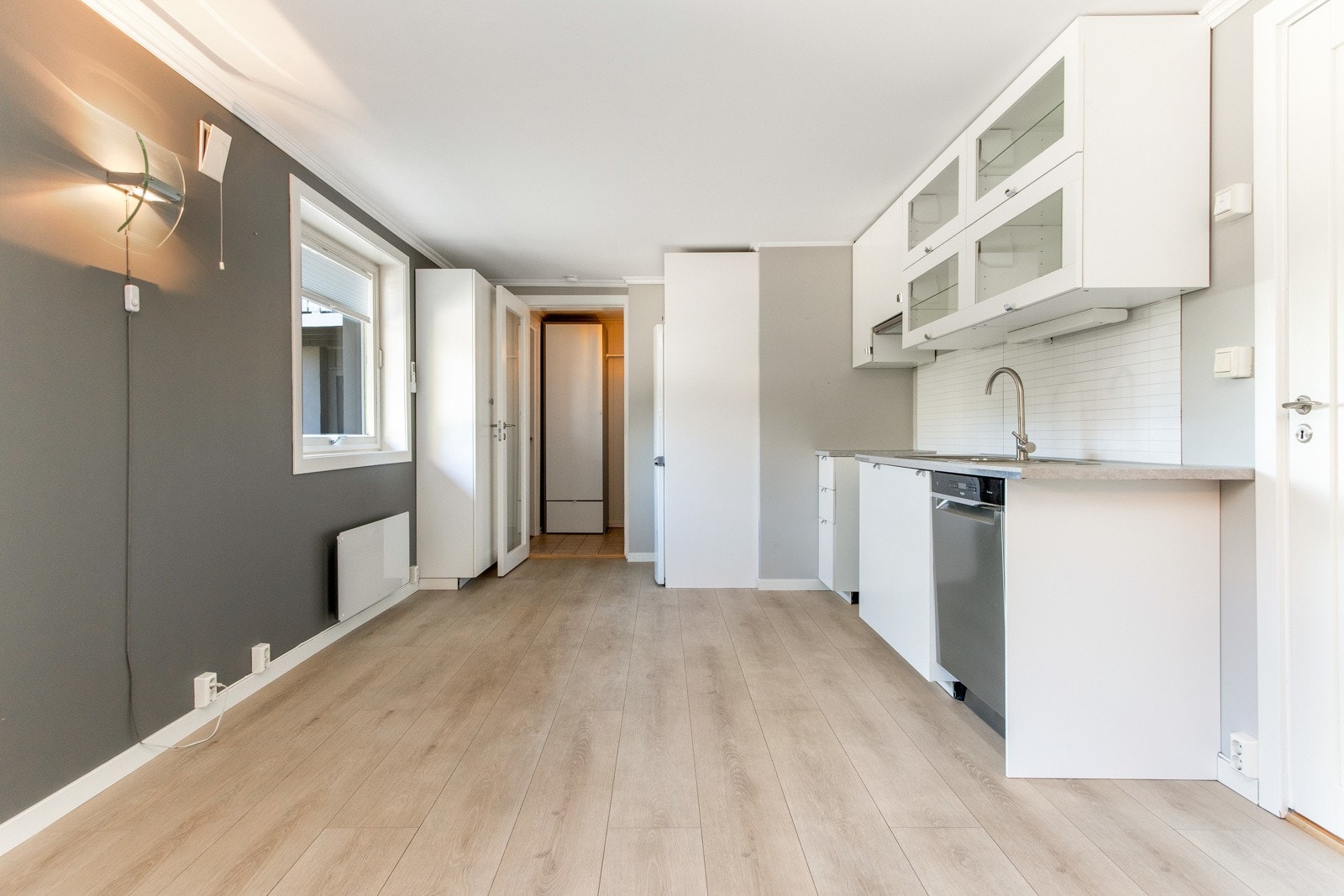 Kjøkkeninnredningen er fra 2020 og har vitrineskap, hvite, glatte fronter og laminert benkeplate med nedfelt oppvaskkum. Galleribilde