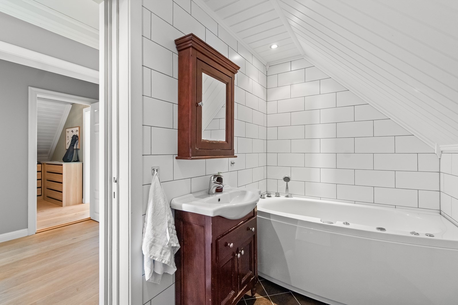 Badet i andre etasje er lyst og tidløst med flislagte overflater og varmekabler i gulvet. Galleribilde