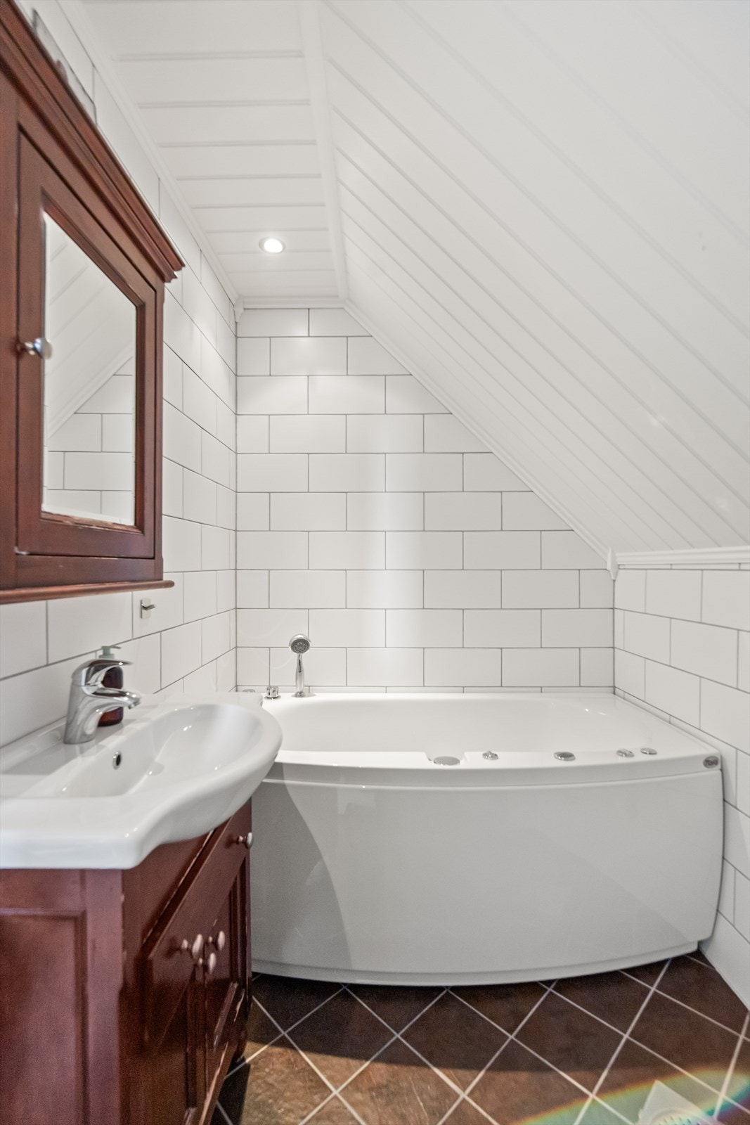 Badet har vegghengt toalett, badekar, servant i baderomsinnredning og opplegg for vaskemaskin. Galleribilde