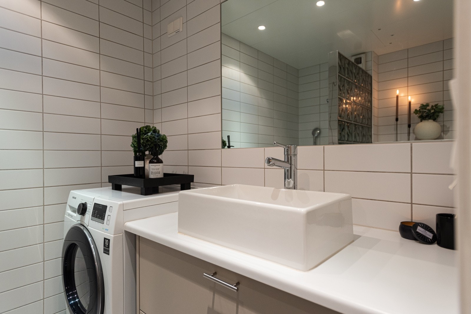 Baderommet, flislagt med gulvvarme, har opplegg og plass til både vaskemaskin og tørketrommel Galleribilde