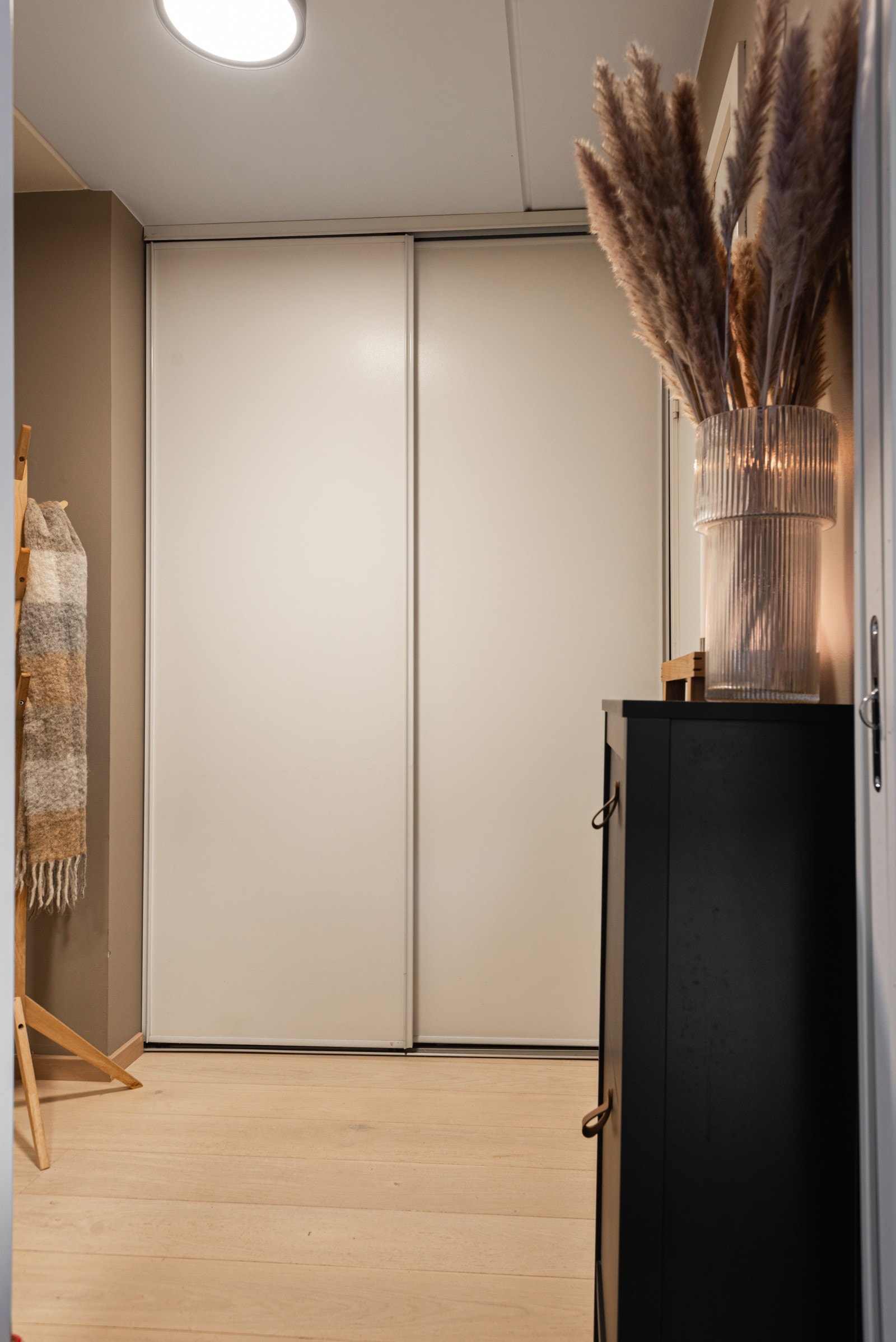 Her finner du en romslig skyvedørsgarderobe for enkel oppbevaring av yttertøy og sko Galleribilde