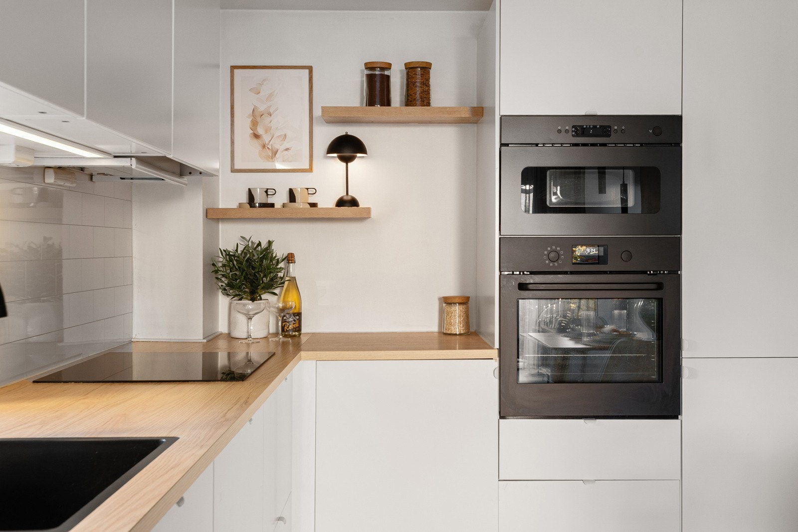 Kjøkkenet er fullt utstyrt med integrerte hvitevarer, inkludert induksjonstopp, stekeovn, mikrobølgeovn, kjøleskap, fryser og oppvaskmaskin Galleribilde