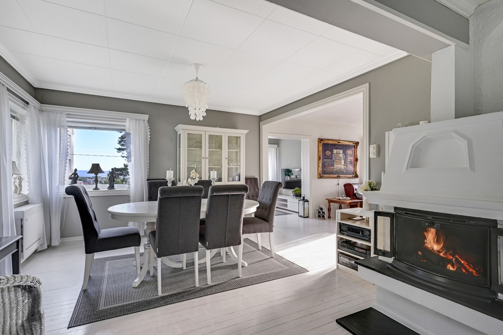 Spisestue med malt tregulv - kjekt også med både peis og varmepumpe Galleribilde