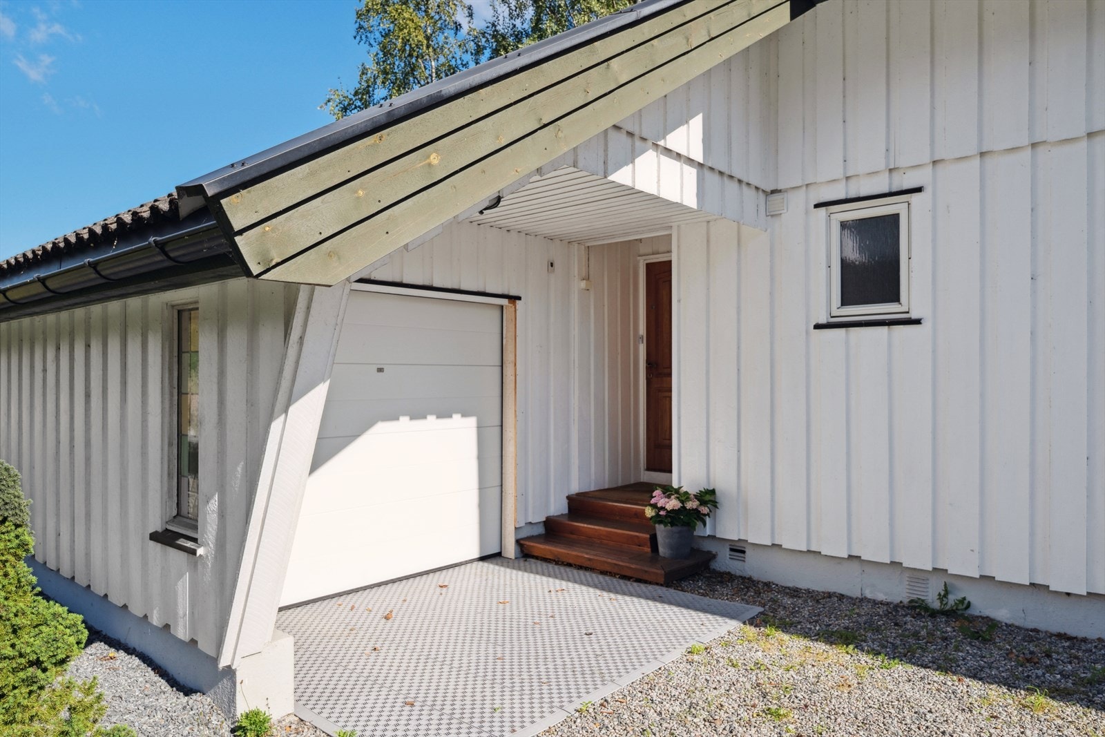 - Garasjen er tilknyttet inngangspartiet og oppført som trekonstruksjon i samme stil som boligen - Galleribilde