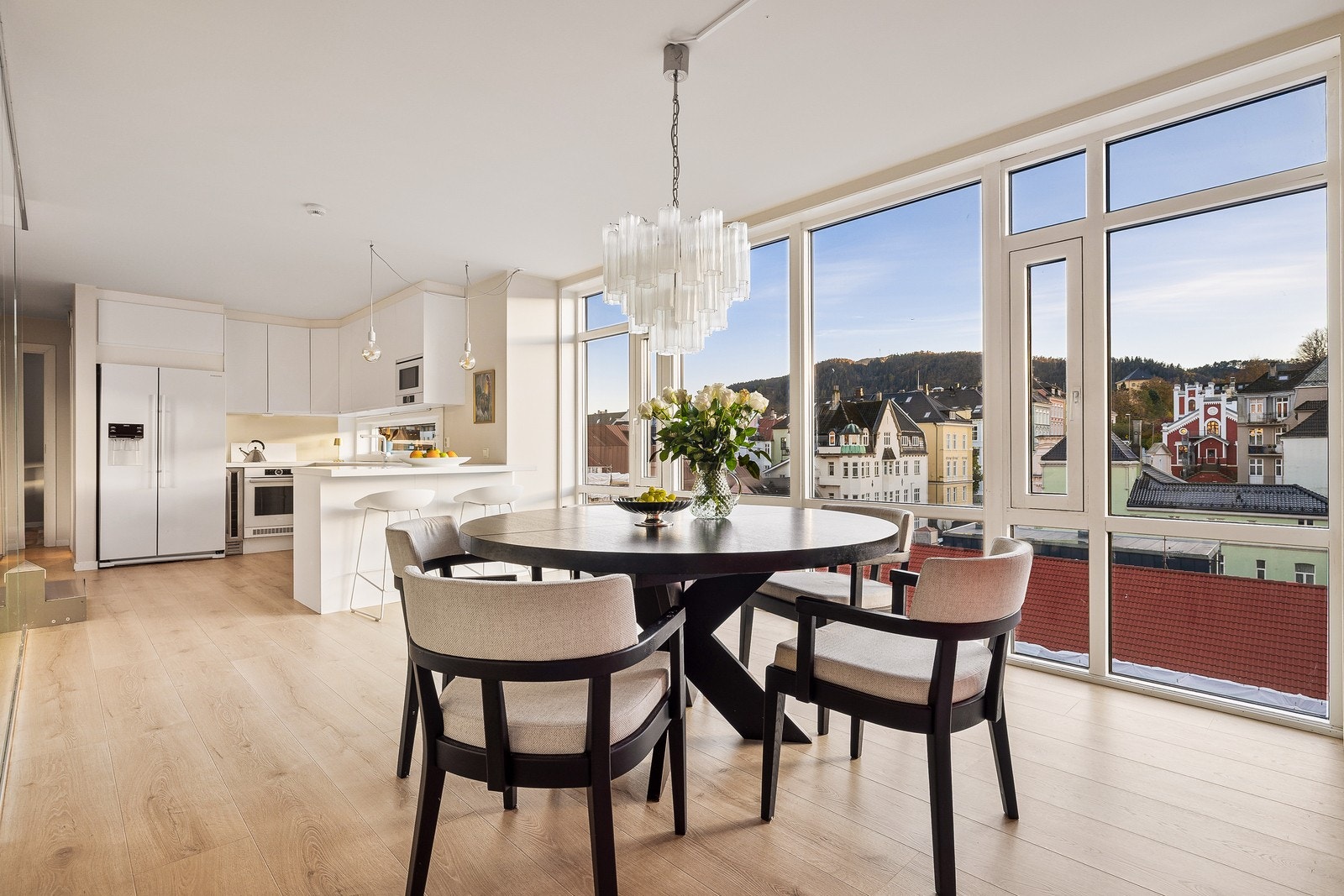 Det er god plass til både sofagruppe og spisebord, og store vindusflater inviterer lyset og utsikten inn, noe som gir en lys og trivelig atmosfære Galleribilde