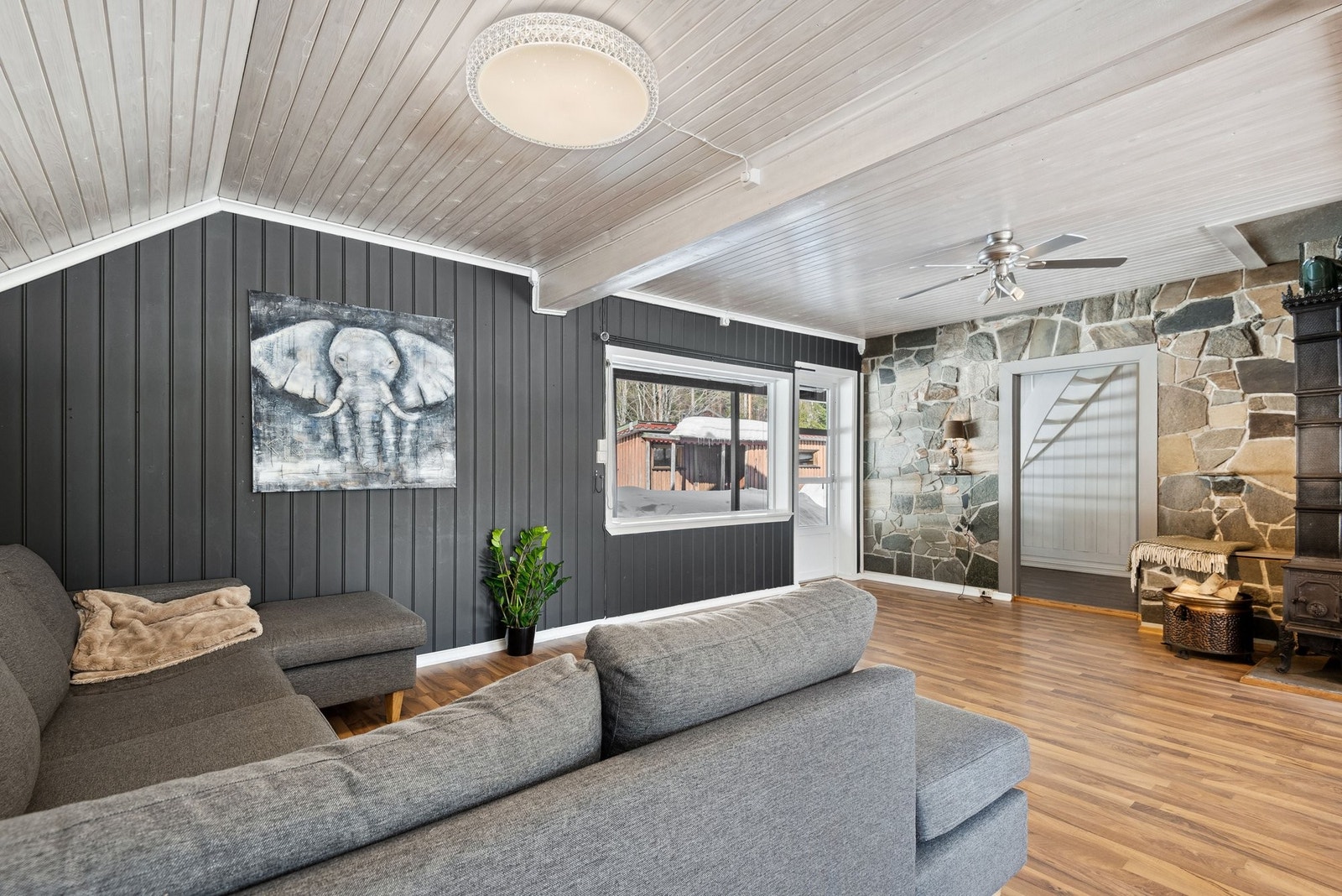 Lys og innbydende stue med store vindusflater Galleribilde