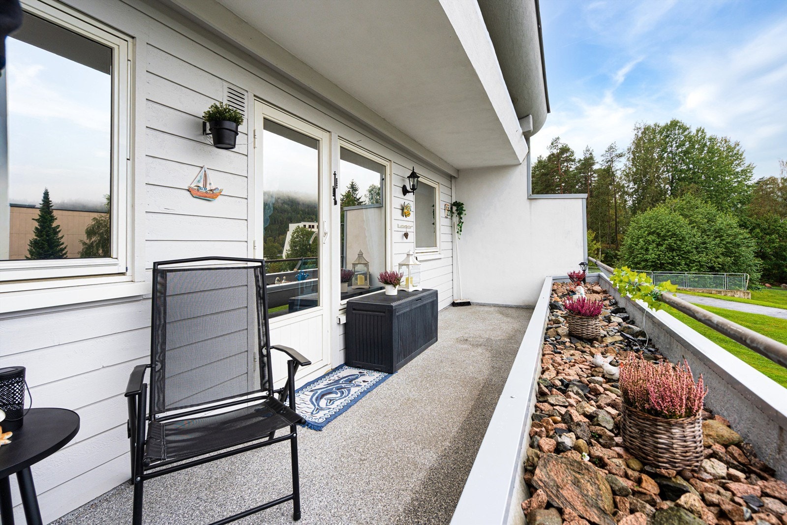 På grunn av skrånet tomt, så sitter man godt hevet over terrenget på denne siden av bygget. Her ute er det åpent utsyn over fellesarealer. Galleribilde