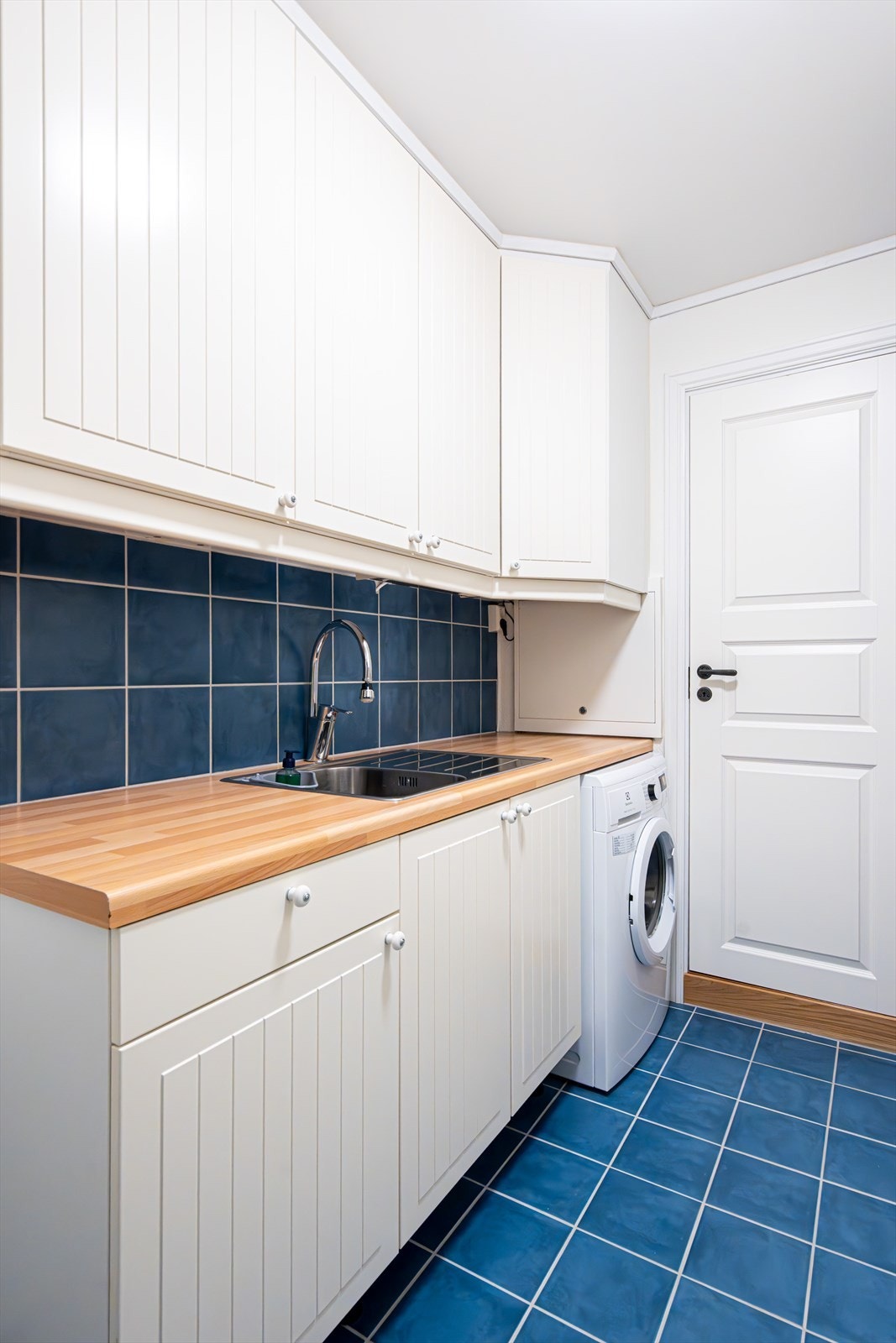 Her er det vask, fryseskap og opplegg for vaskemaskin. Det er gulvvarme i rommet. Galleribilde