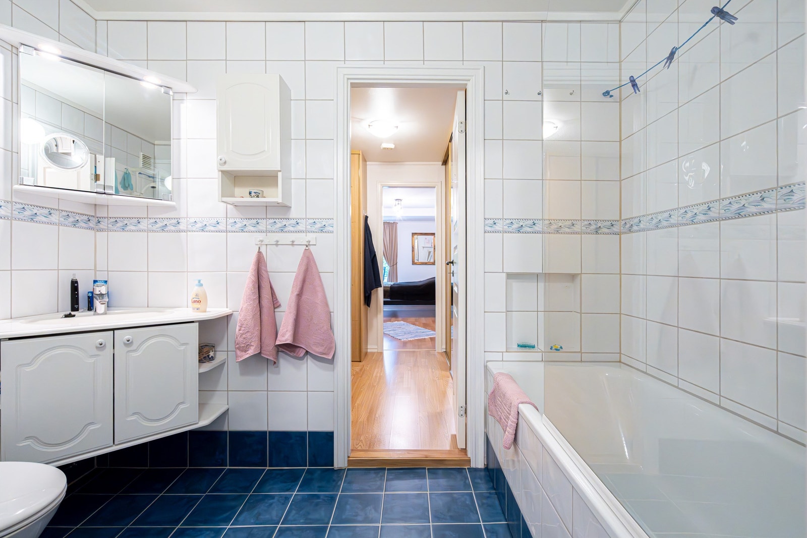 Videre kommer man til hovedbadet, som holder eldre standard, men er funksjonelt i dagens bruk med dusj i badekar. Det er varmekabler i gulv. Galleribilde