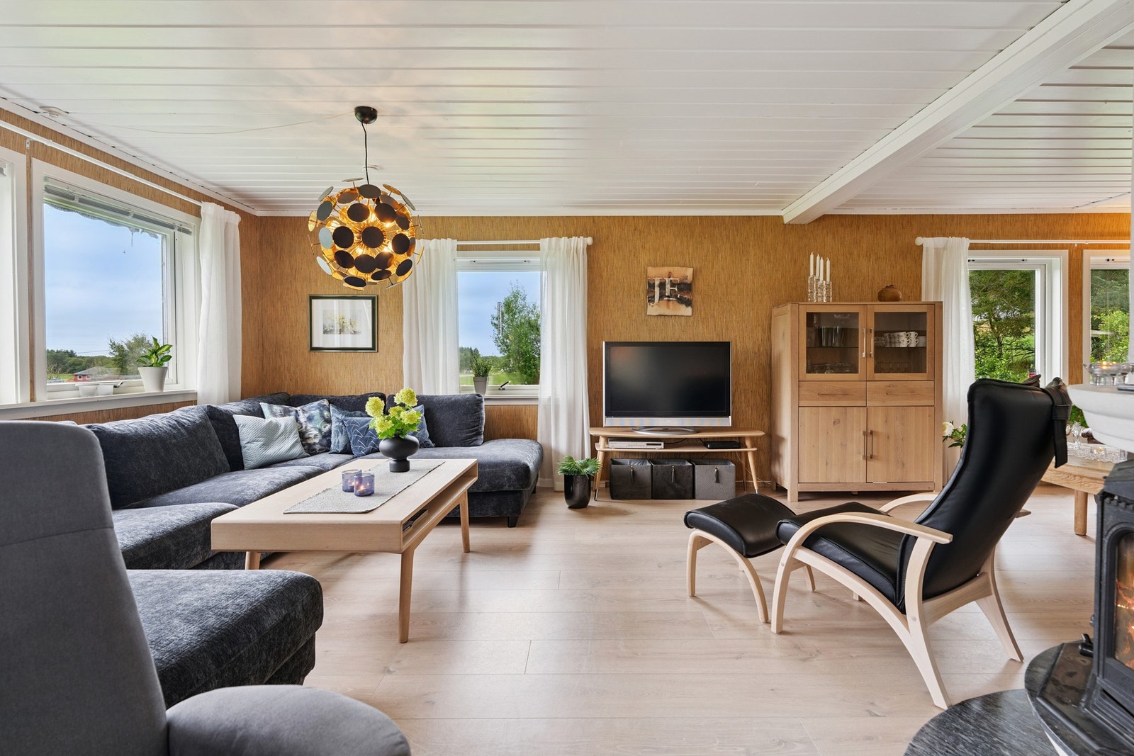 Romslig stue med god plass til både sofagruppe og spisebord. Store vindusflater gir rikelig med dagslys og fin utsikt mot hagen. Vedfyring gir en lun og hyggelig atmosfære. Galleribilde