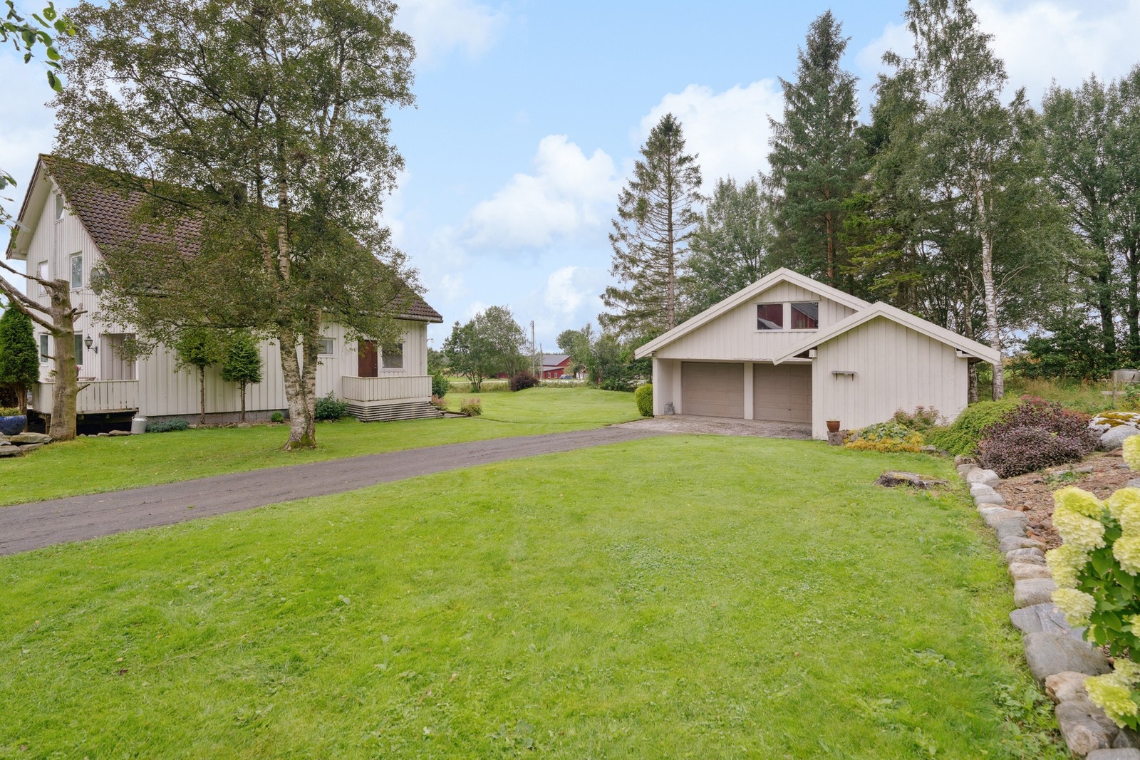 Garasje med plass til to biler og ekstra lagring. Praktisk plassering på tunet med enkel adkomst og tilknytning til våningshuset. Galleribilde