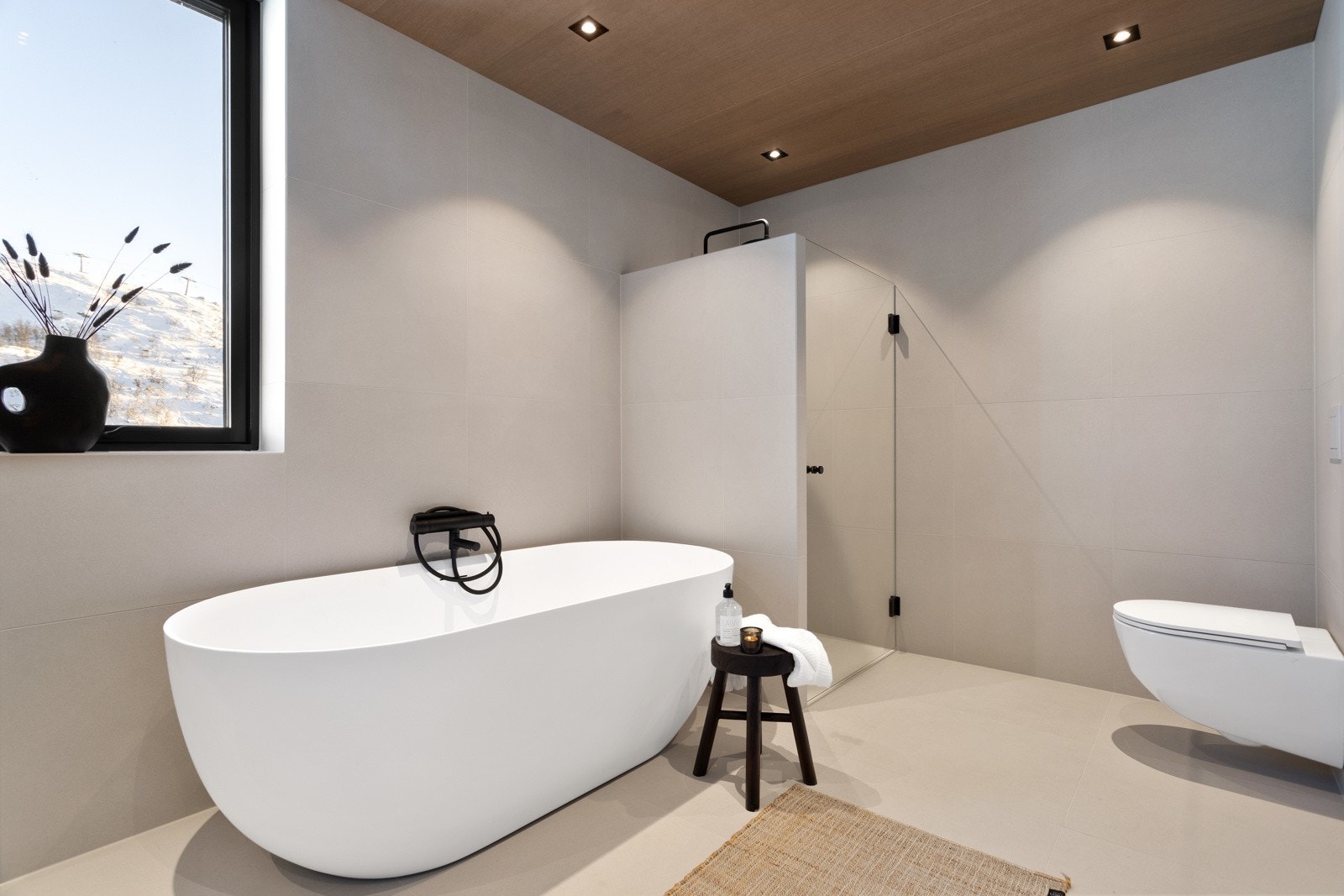 Badet inneholder innredning med toppmontert servant og speil, dusjnisje med waterfall armatur, badekar, vegghengt toalett og badstue Galleribilde