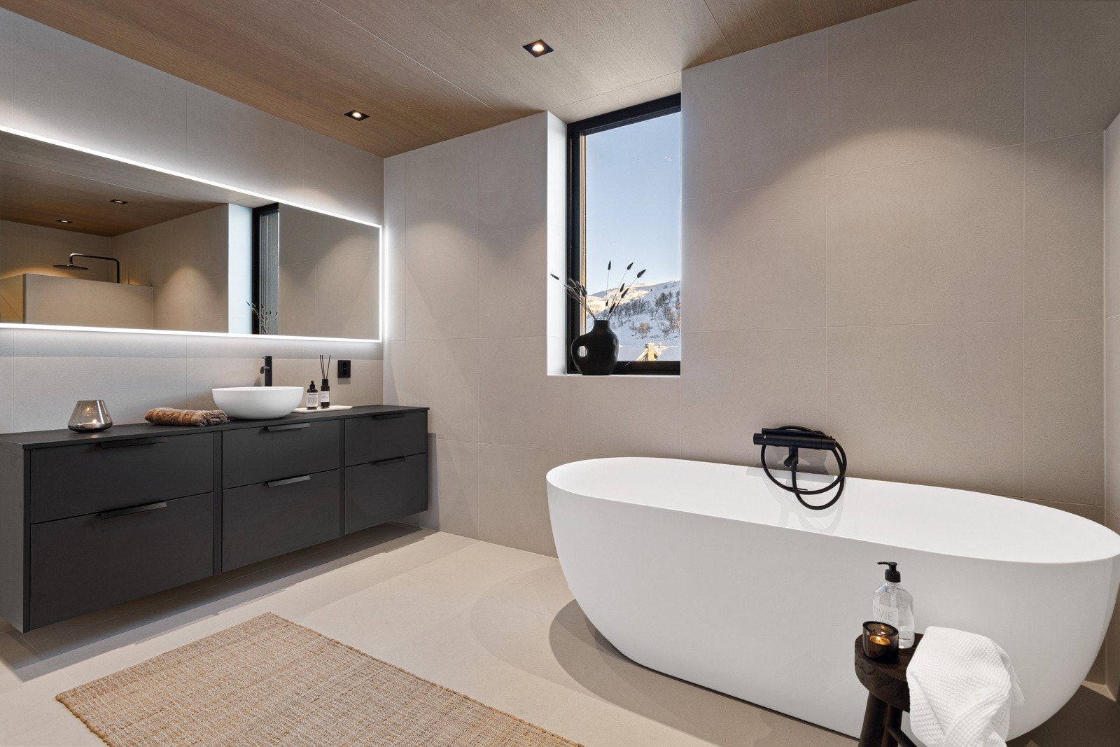 Lekkert og tidsmessig baderom med eksklusive, lyse fliser på gulv og vegger Galleribilde