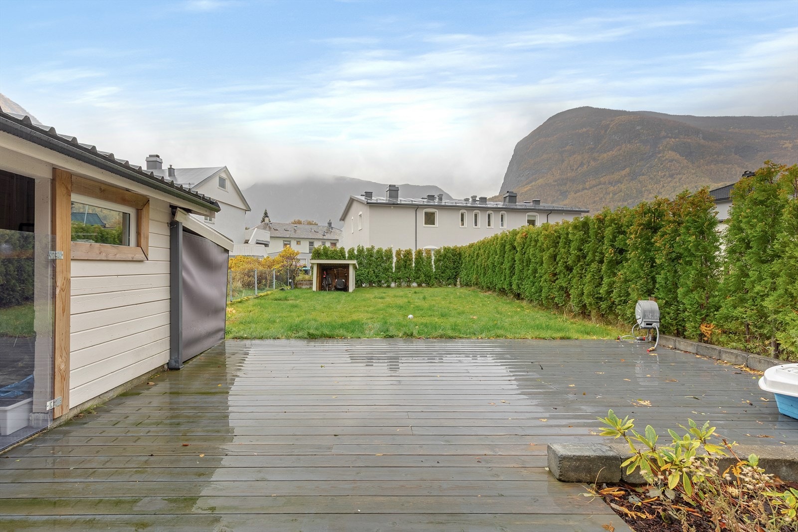 Fin uteplass med terrasse og grøntareal. Det er også boder til oppbevaring. Galleribilde