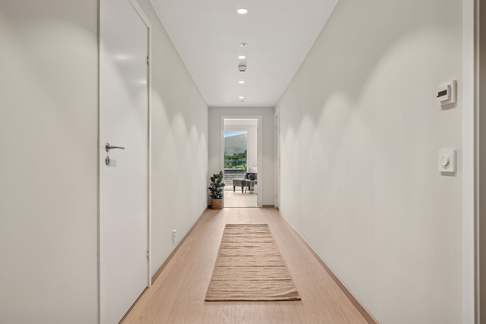 Lys og romslig gang med vannbåren gulvvarme og balansert ventilasjon. Listefrie overflater, lyse vegger og kvalitets parkett er gjennomgående og skaper et moderne og rent uttrykk. Galleribilde