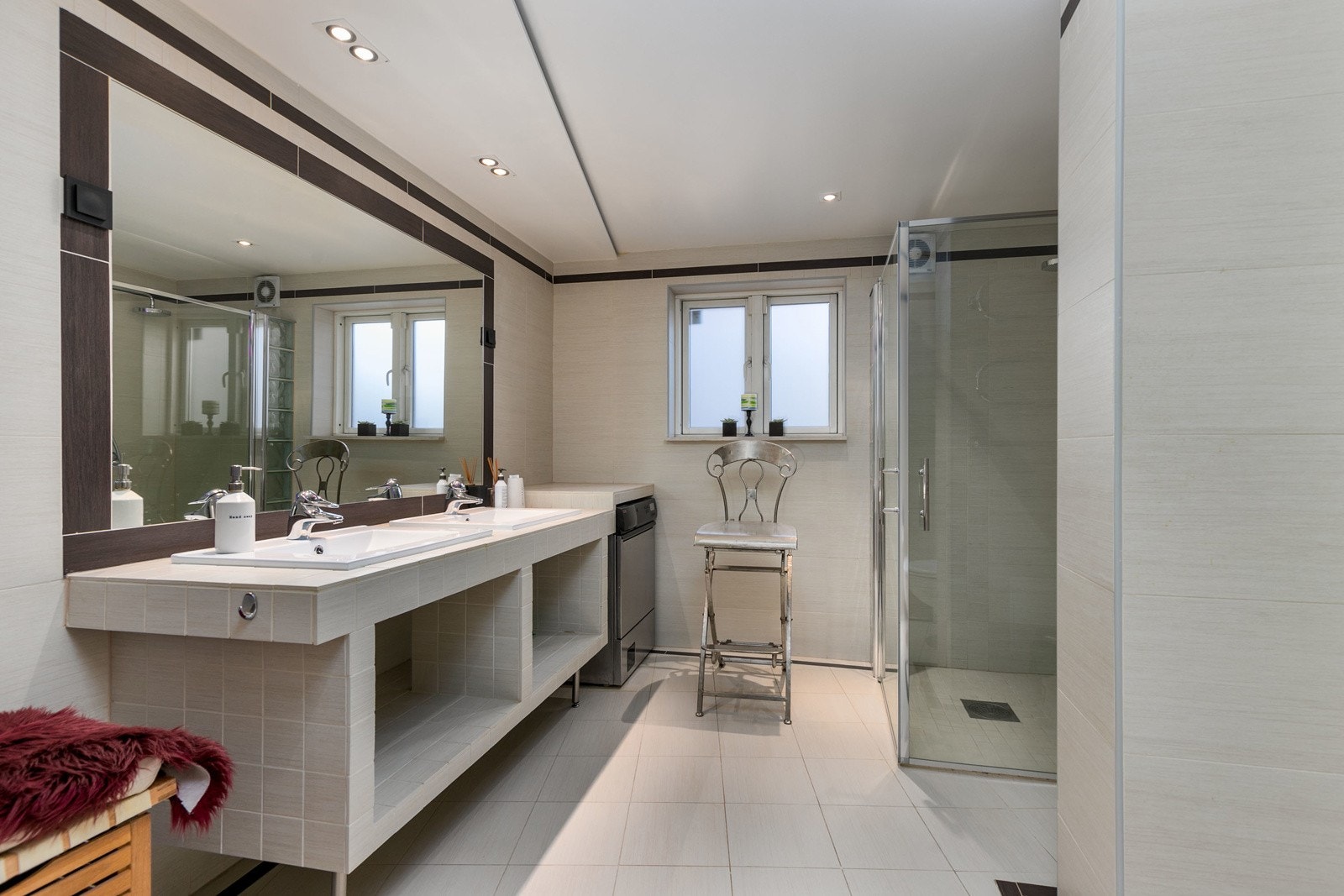 Romslig bad i kjeller etasjen, med fliser på gulv og vegger. Varme i gulv. Dusjsone med innfellbare dører. Galleribilde