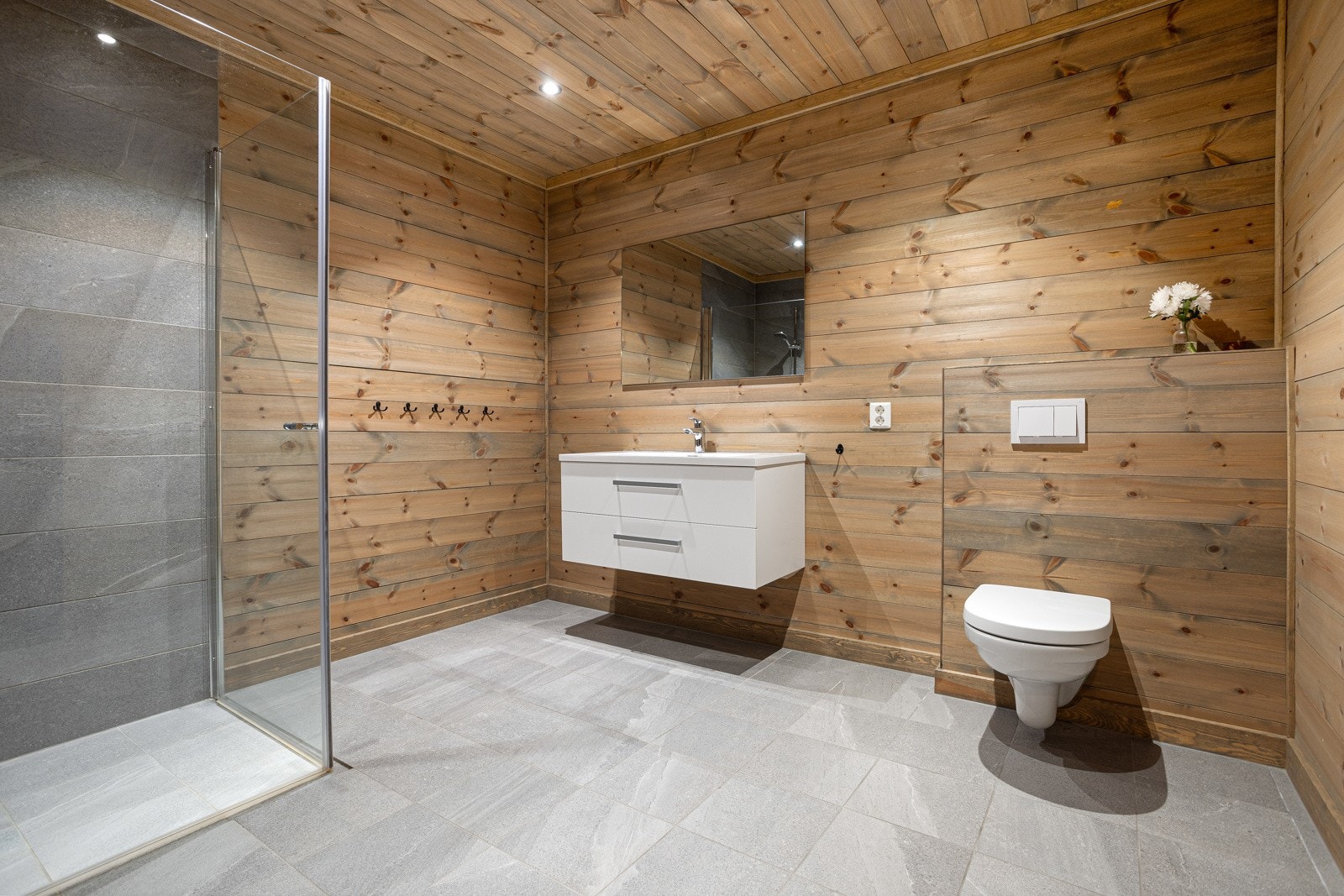 Lekkert og tidsmessig baderom i underetasje. Badet inneholder innredning med toppmontert servant og speil, dusjnisje med glassvegger, samt toalett Galleribilde