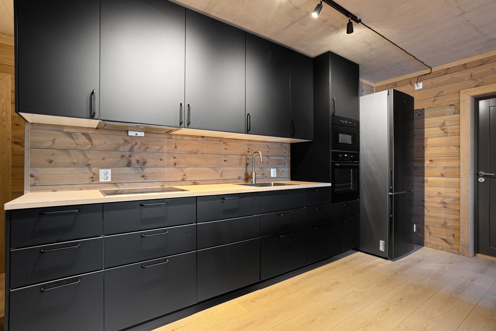 Kjøkkenet har integrerte hvitevarer som induksjon platetopp, ventilator stekeovn, mikro, oppvaskmaskin og kjøleskap med frysedel Galleribilde