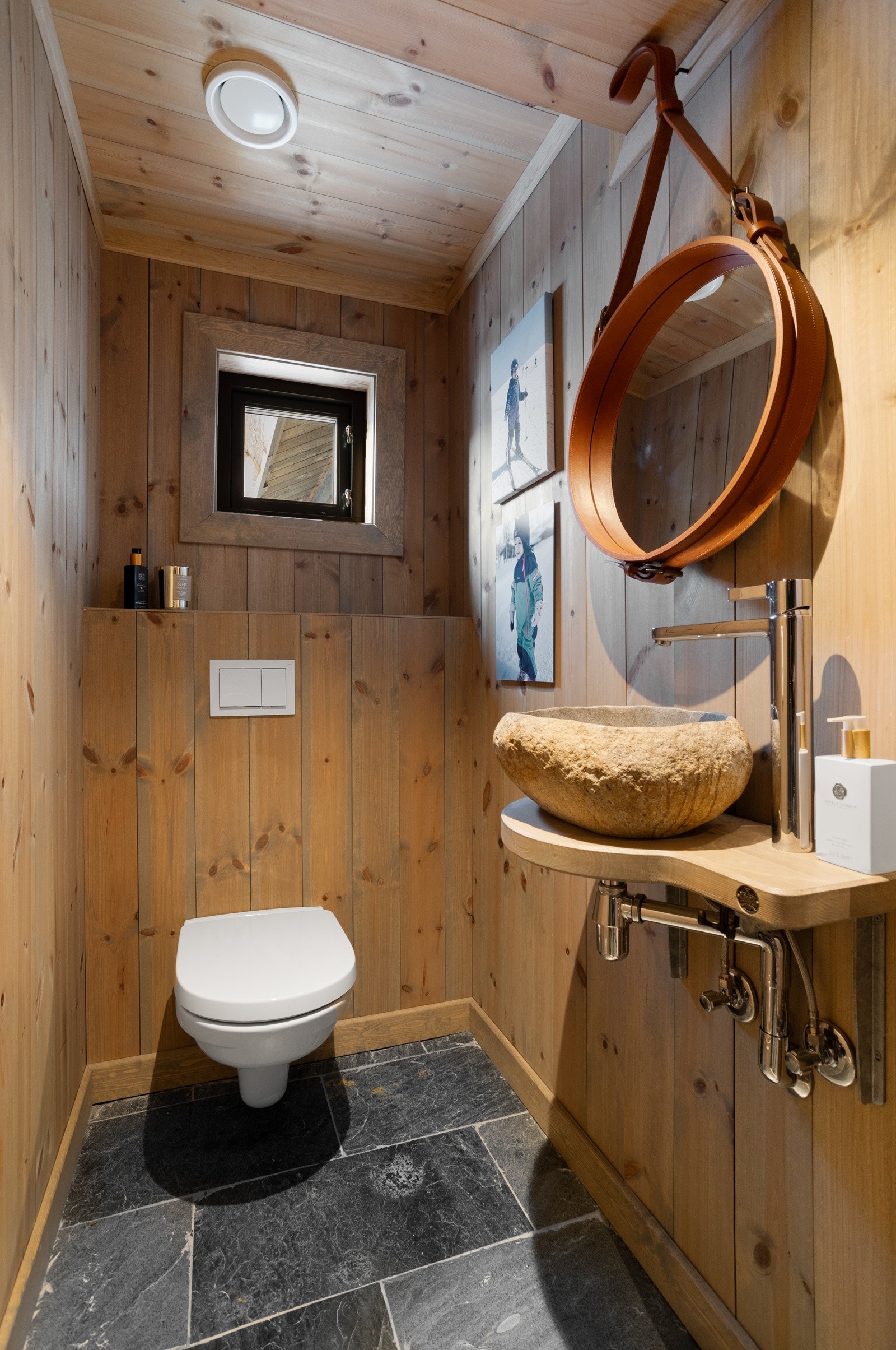 Praktisk toalettrom innredet med toalett, servant med innredning og speil. Rommet har direkte inngang fra entreen slik at man kan beholde skiskoene på Galleribilde