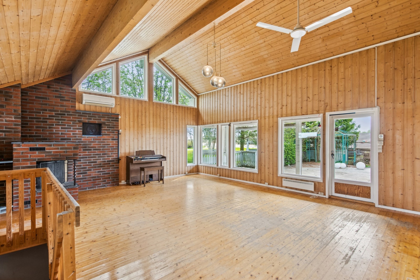 Tilbygget stue er luftig og lys med høy skråhimling og spennende vindusdetaljer. Dør ut til terrassen Galleribilde