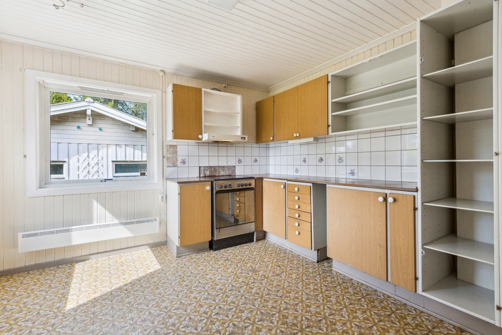 Eldre kjøkken med skader på innredning og overflater. Rommet har behov for oppgradering og modernisering Galleribilde