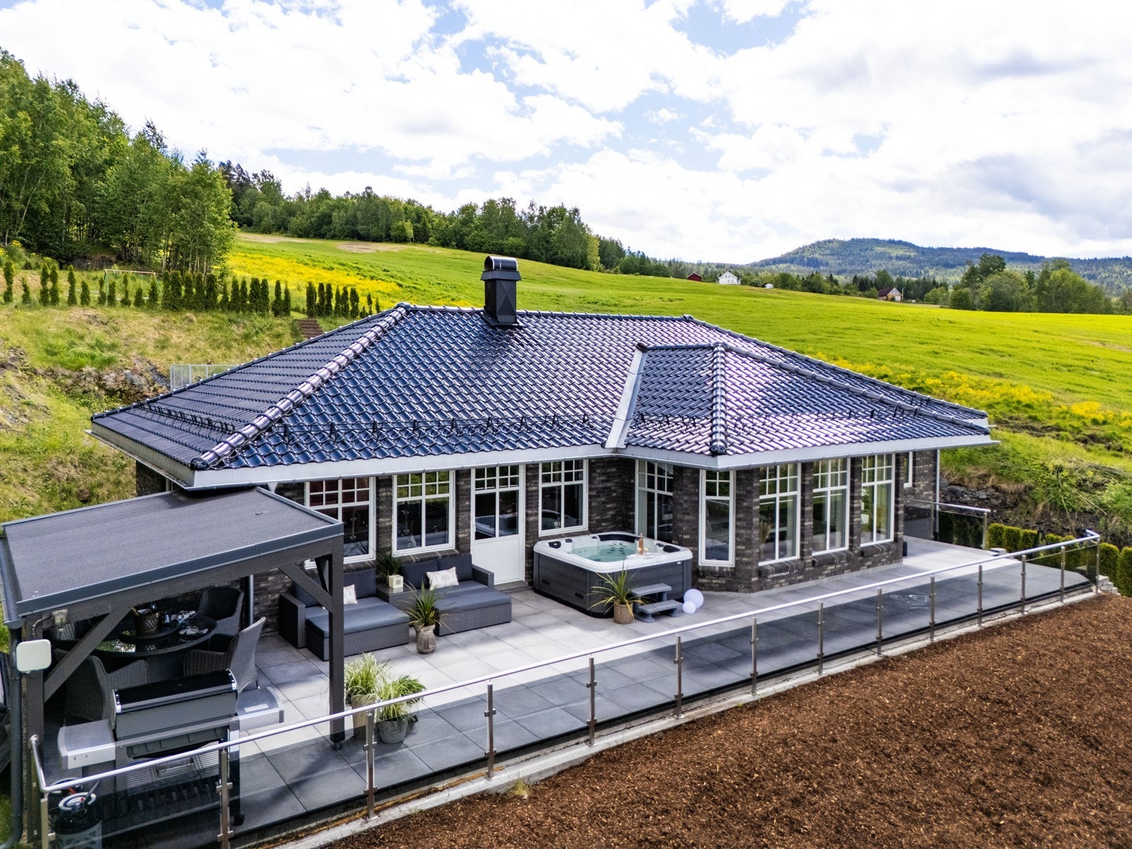 Huset er bygget i tegl, har glassert takstein og moderne aluminiumsbelagte vinduer - materialvalg som gir både lang levetid og et særegent, stilrent uttrykk. Galleribilde