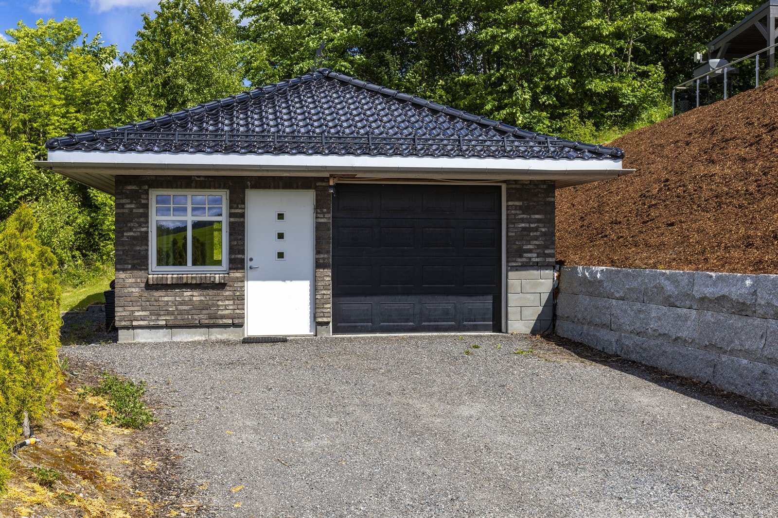 Nedenfor boligen har man også en frittstående garasje oppført i samme stil som huset. Galleribilde