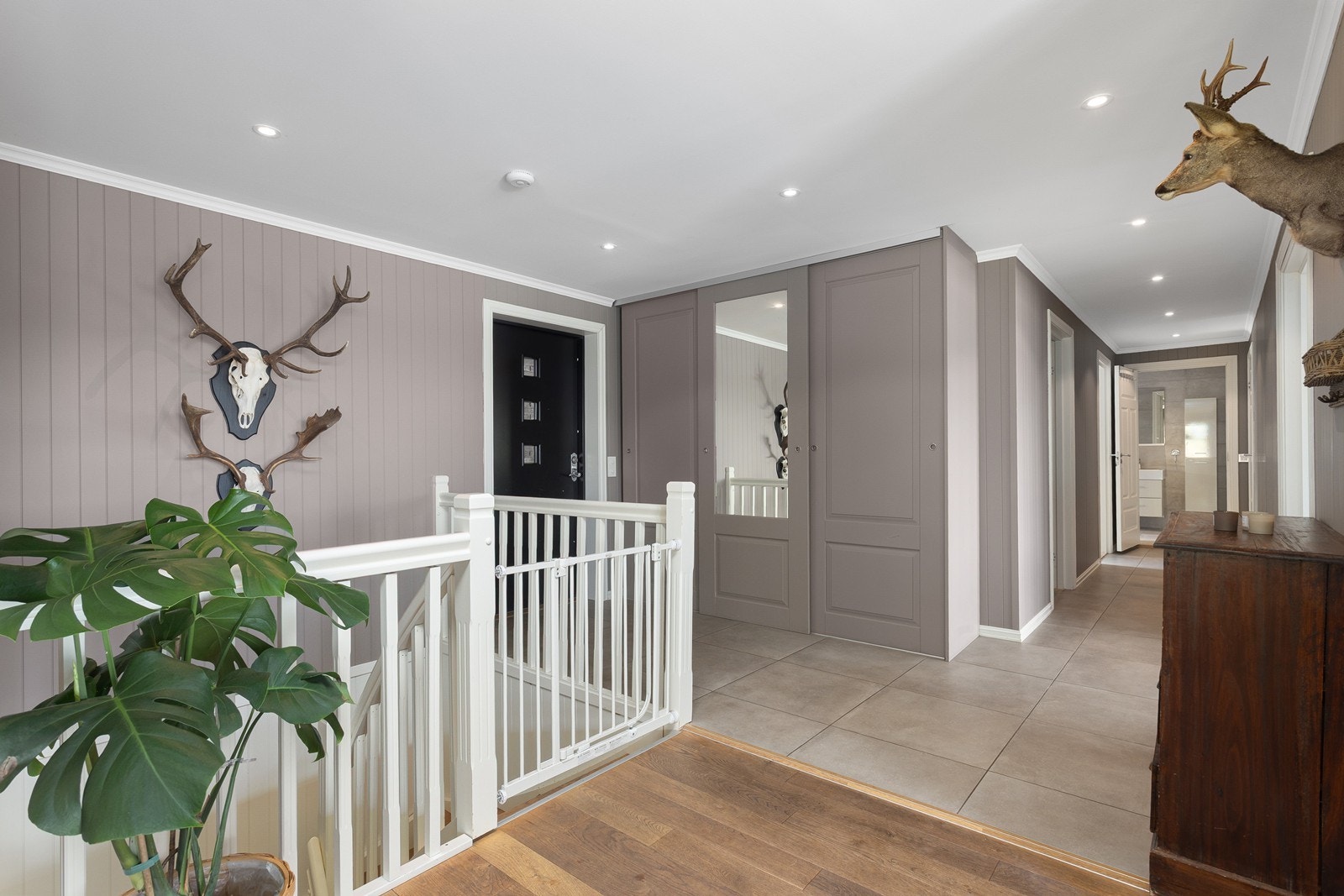 Man ønskes velkommen inn i en lys og innbydende entre med flislagt gulv, åpen løsning og god oppbevaringsplass i garderobeskap. Galleribilde