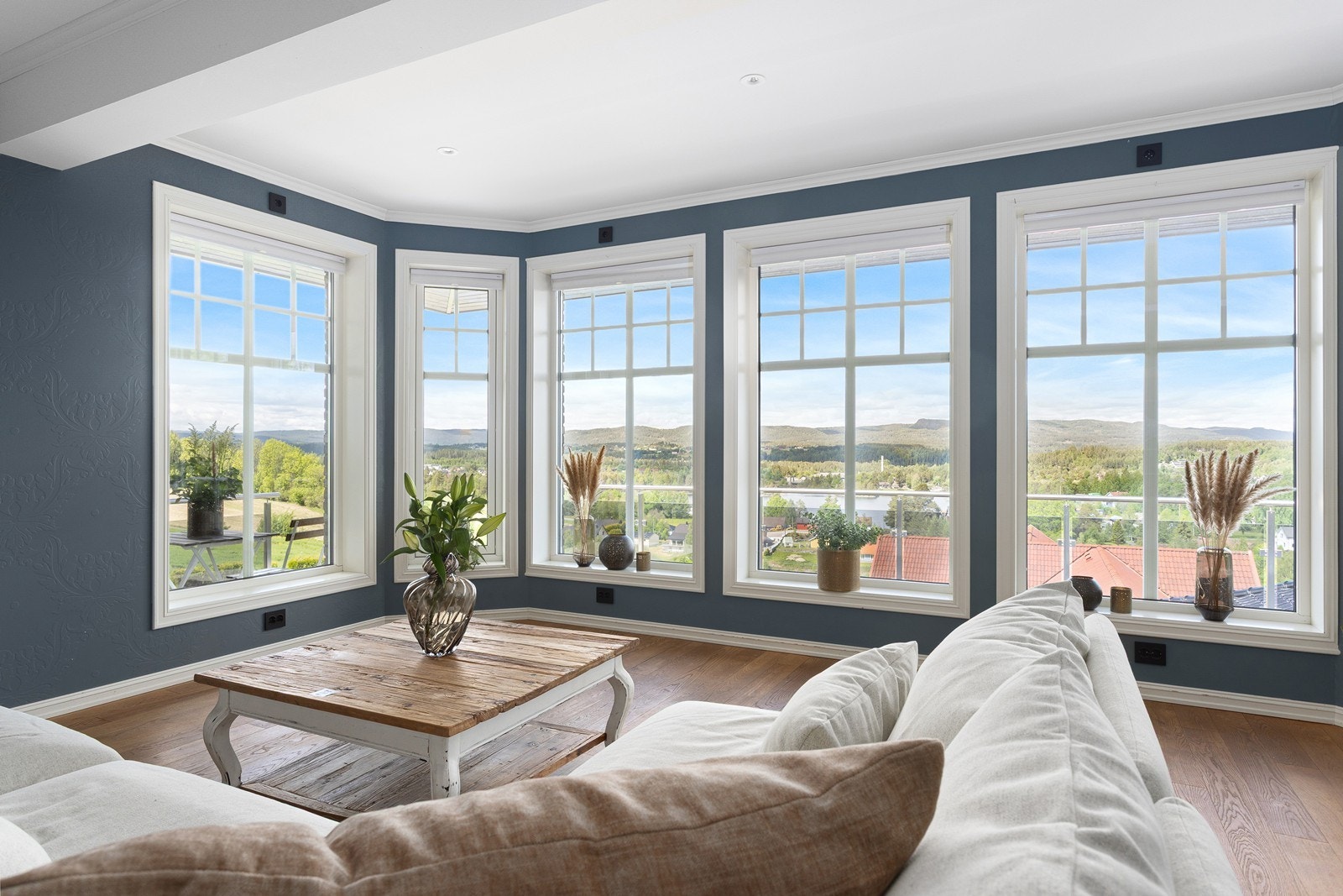 Boligen har en lys og innbydende stue med store panoramavinduer som fyller rommet med naturlig lys. Galleribilde