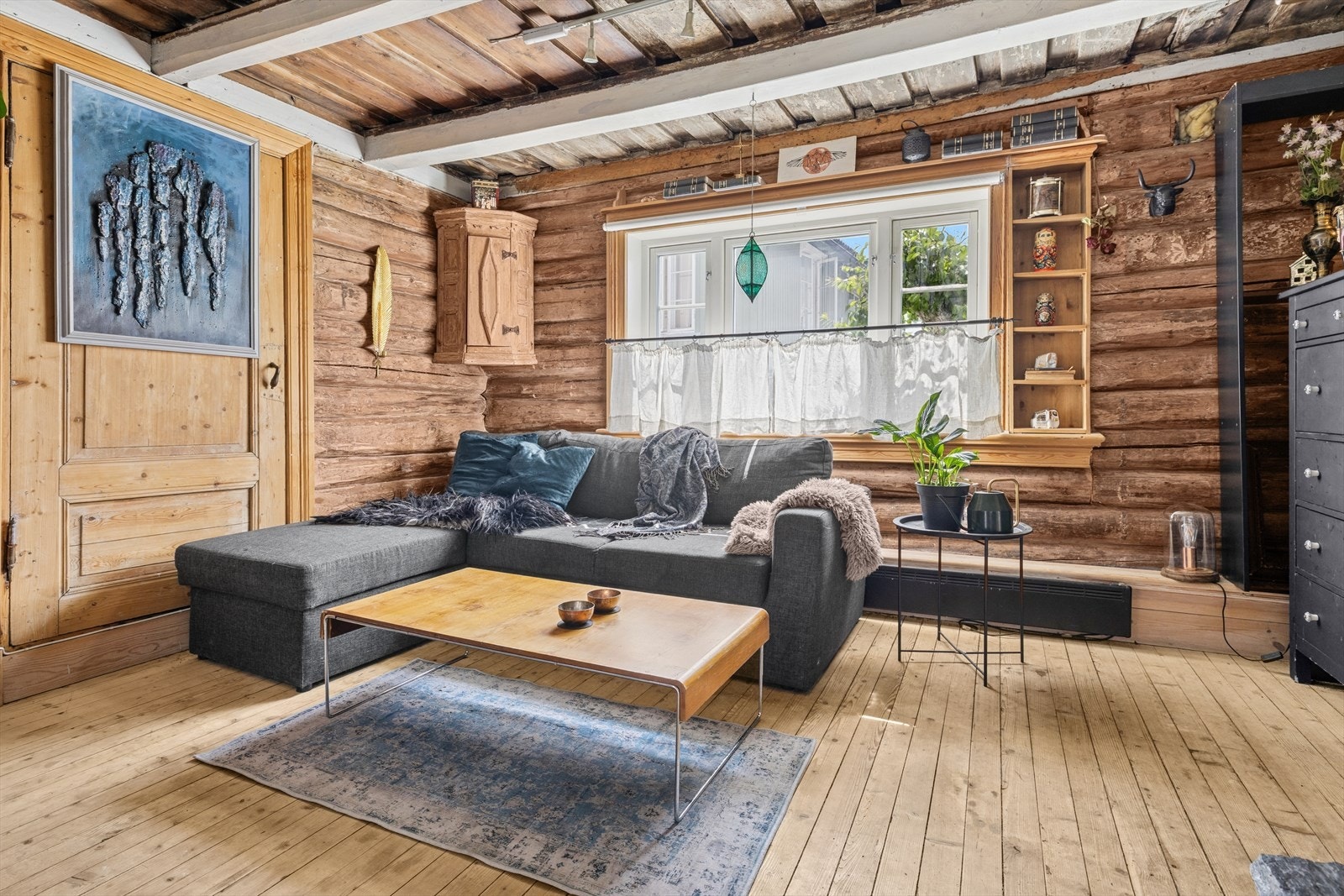 Stuen har flotte tømmervegger og synlige bjelker i taket Galleribilde
