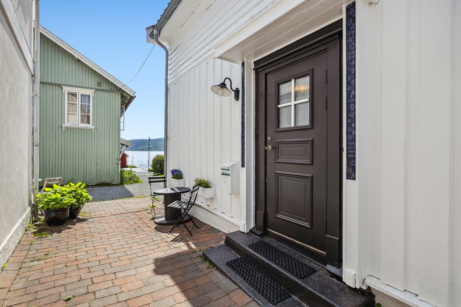 Koselig uteplass ved den steinlagte adkomsten til boligen Galleribilde