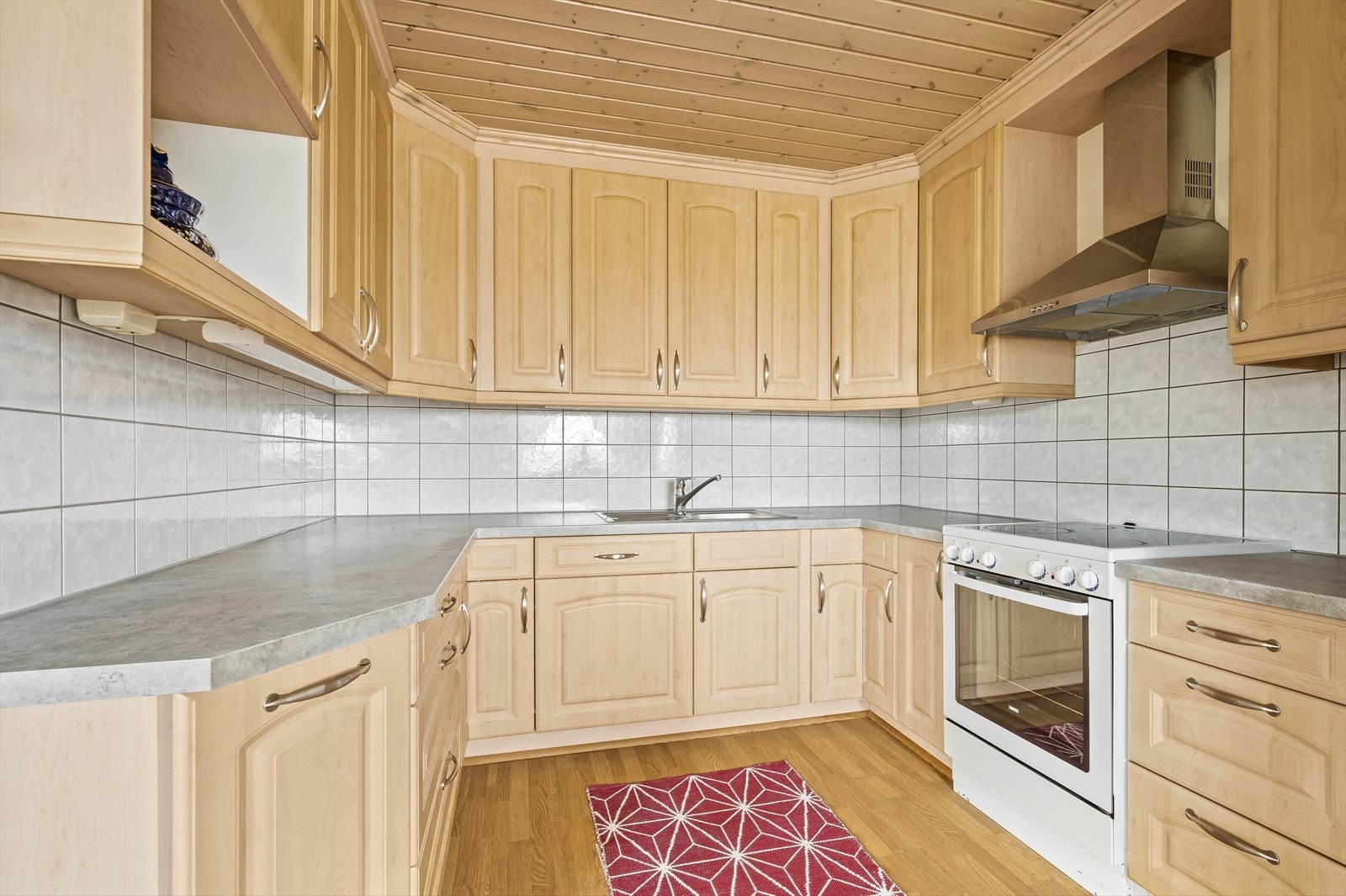 Pent kjøken med overskap til tak og rikelig med både skap- og benkplass. Galleribilde