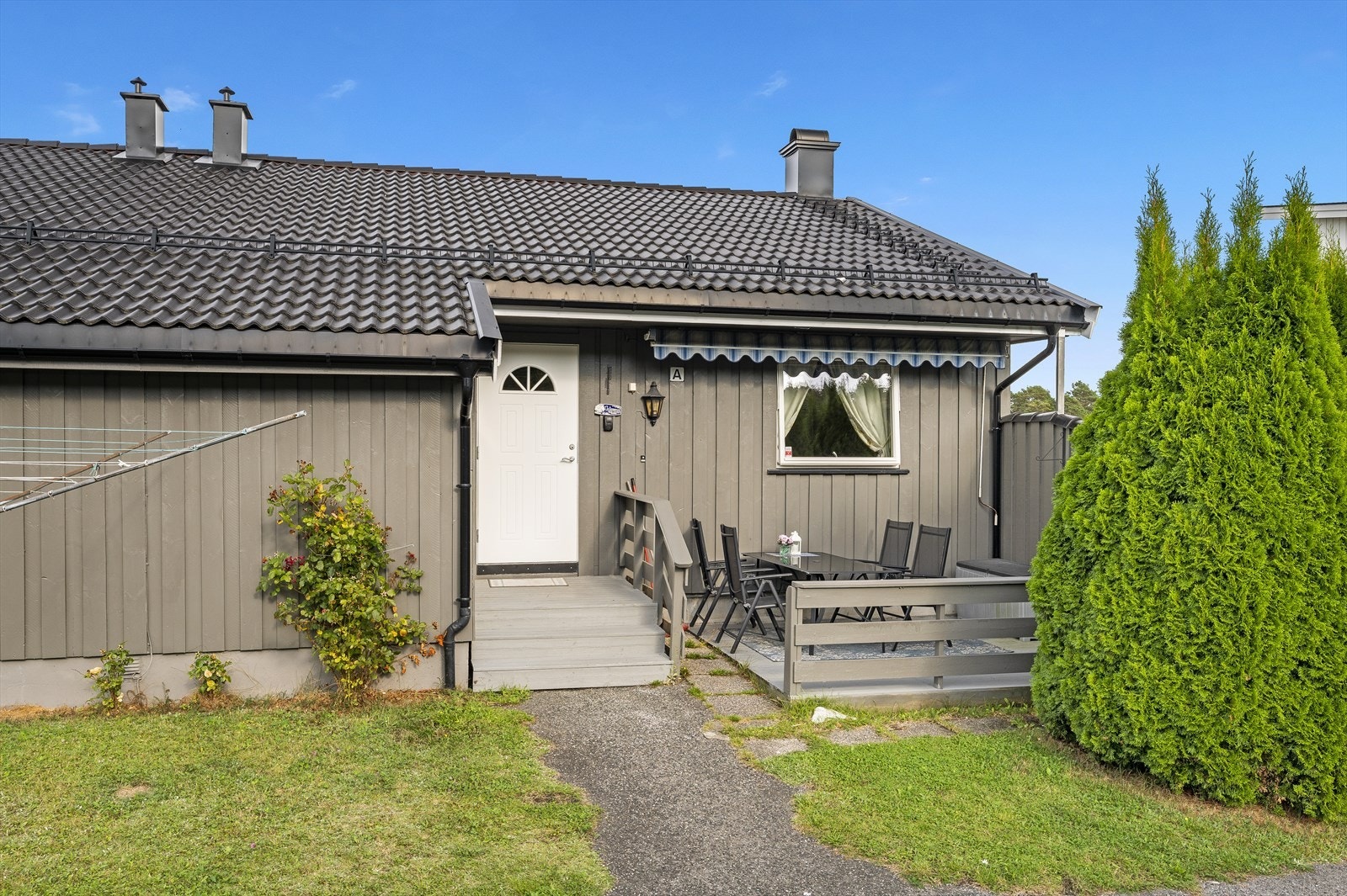 Inngangspartiet på denne topp-/hjørneleiligheten. Fin, usjenert terrasseplatting og enkel adkomst rett fra bakkeplan. Galleribilde