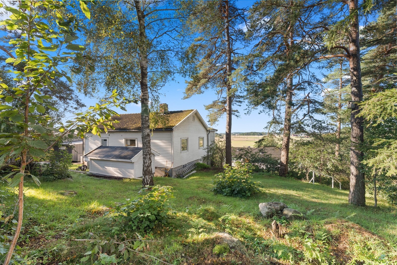 Naturlige omgivelser med litt skog i bakkant av tomten, som gir en rolig og privat atmosfære. Galleribilde
