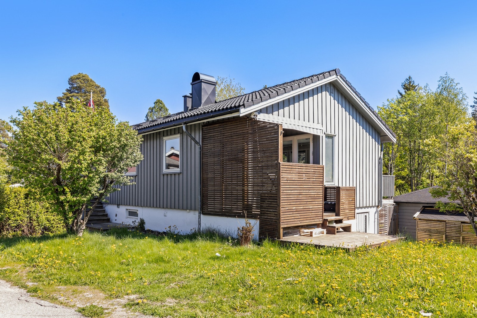 Vestvendt terrasseplatting med skillevegger, rekkverk og terrassegulv i treverk Galleribilde